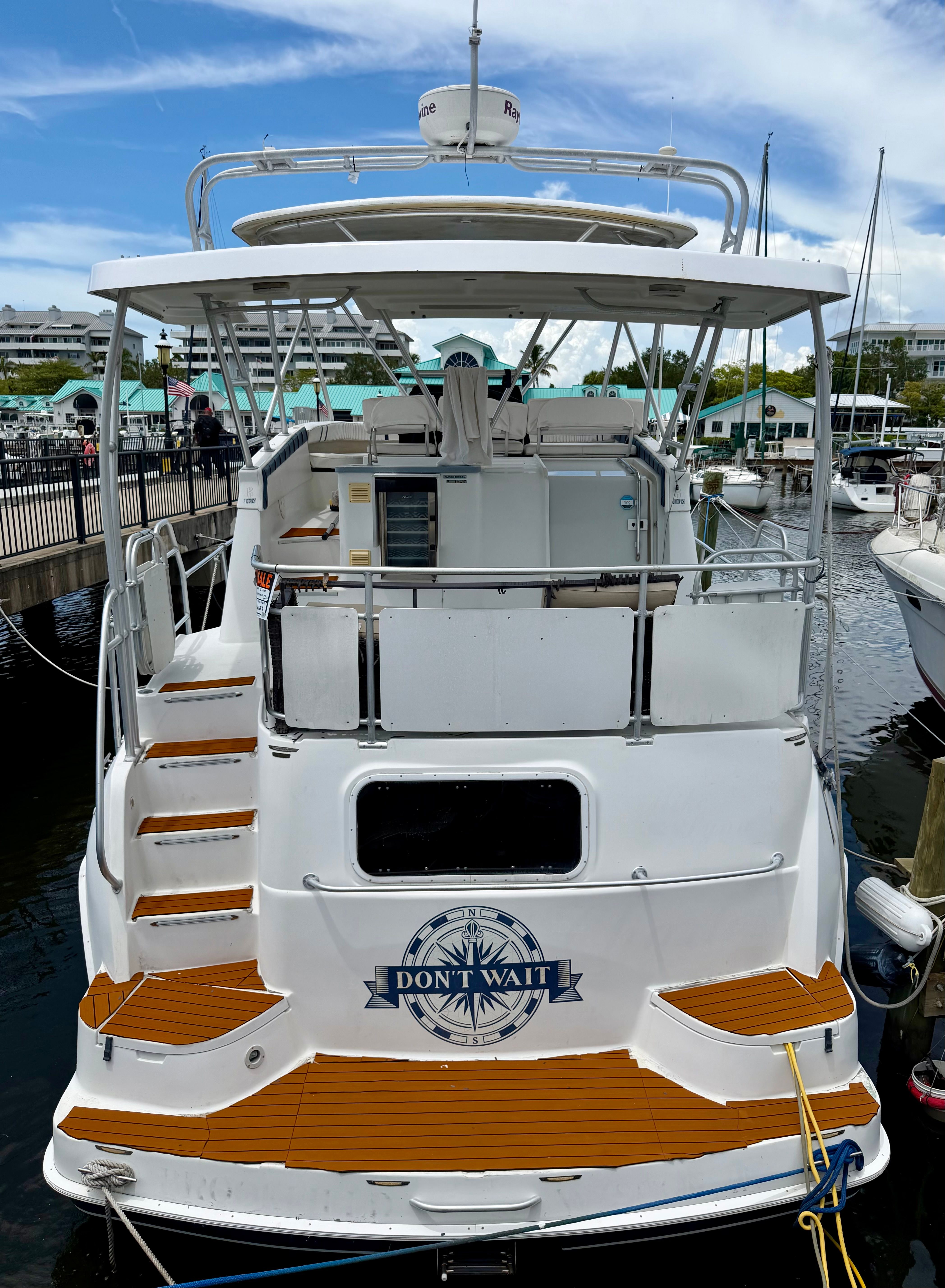 Aft view of a 1995 Mainship 37 docked, featuring wooden details.