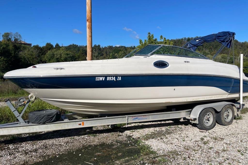 2004 Sea Ray 240 Sundeck boat on trailer, parked outdoors.