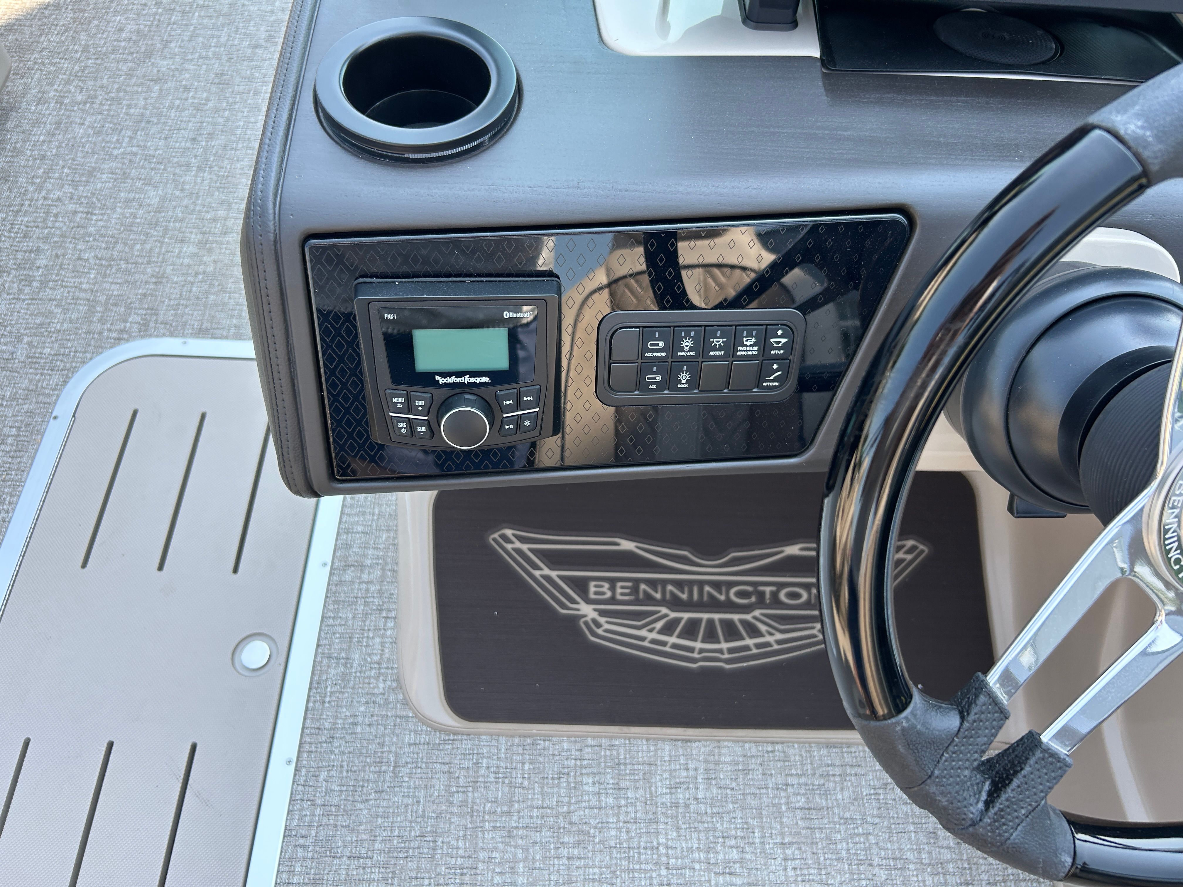 The image shows the helm of a Bennington 22 MFB boat with a modern audio system.
