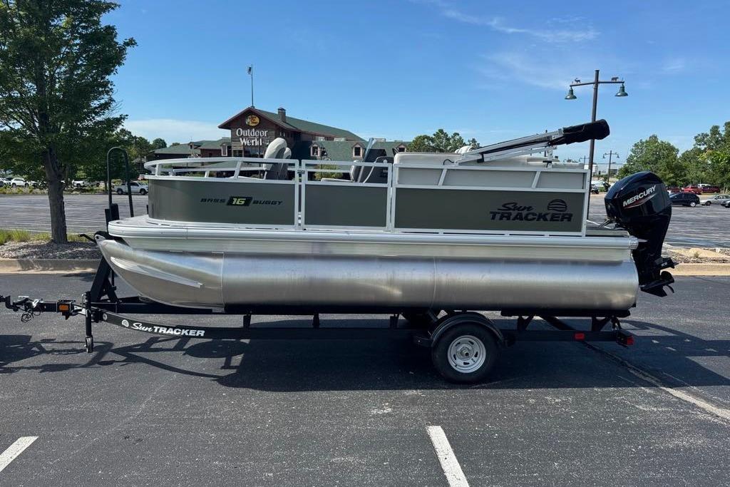 2026 Sun Tracker Bass Buggy 16 XL Select pontoon boat on trailer in parking lot.