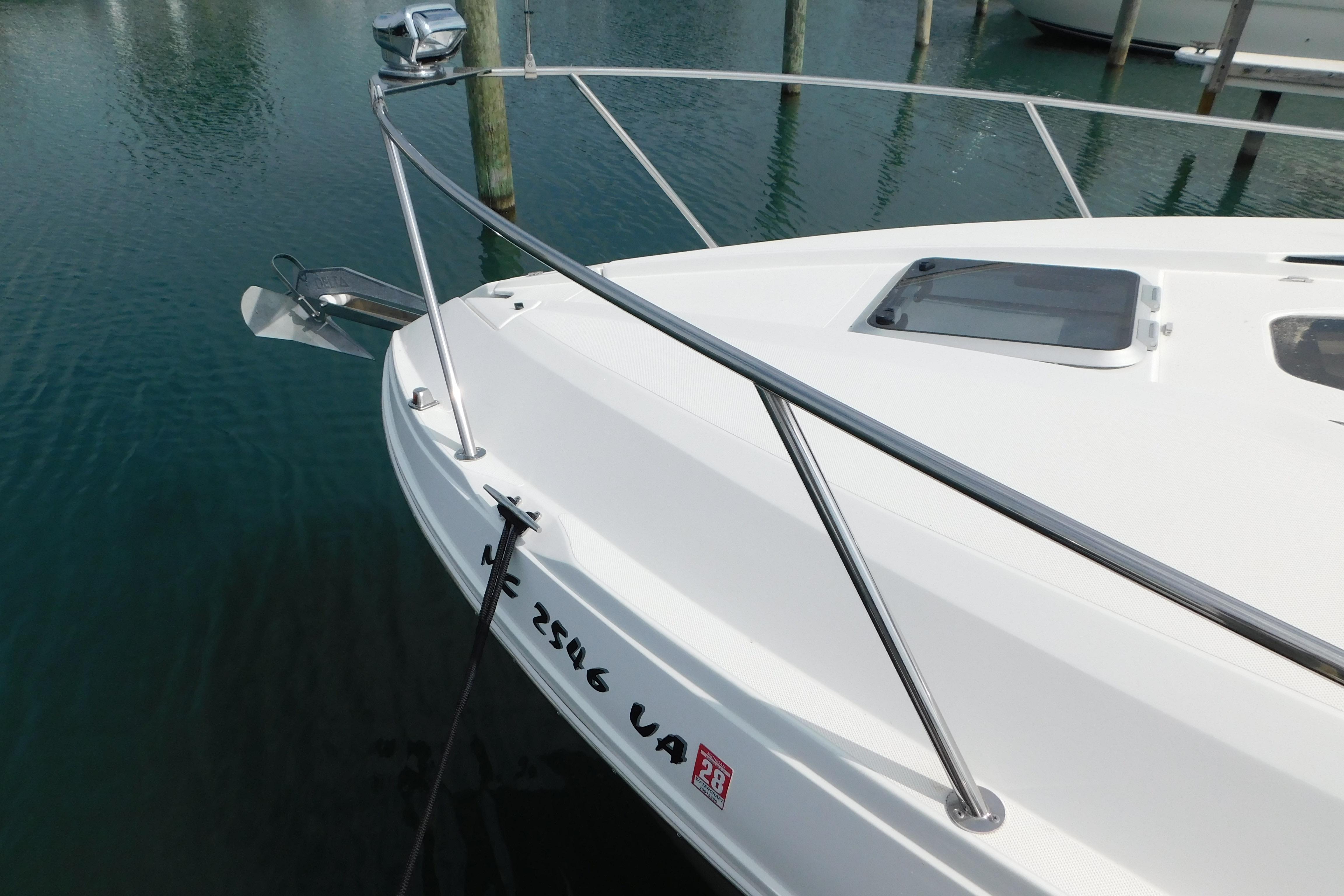 2017 Rinker EX 320 boat docked, featuring sleek white deck and stainless steel railings.