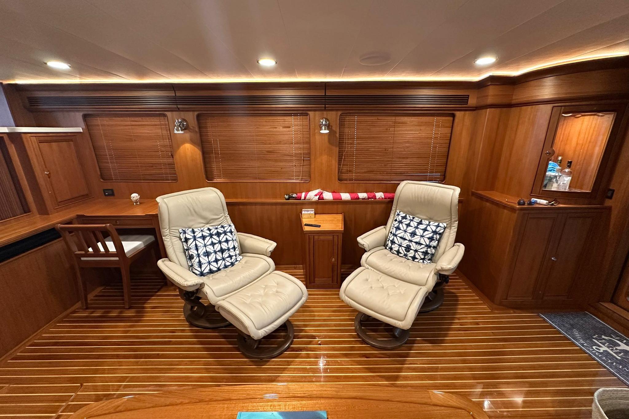 Luxurious interior of 2023 Marlow Explorer 66E-CB yacht with plush seating and wooden finishes.