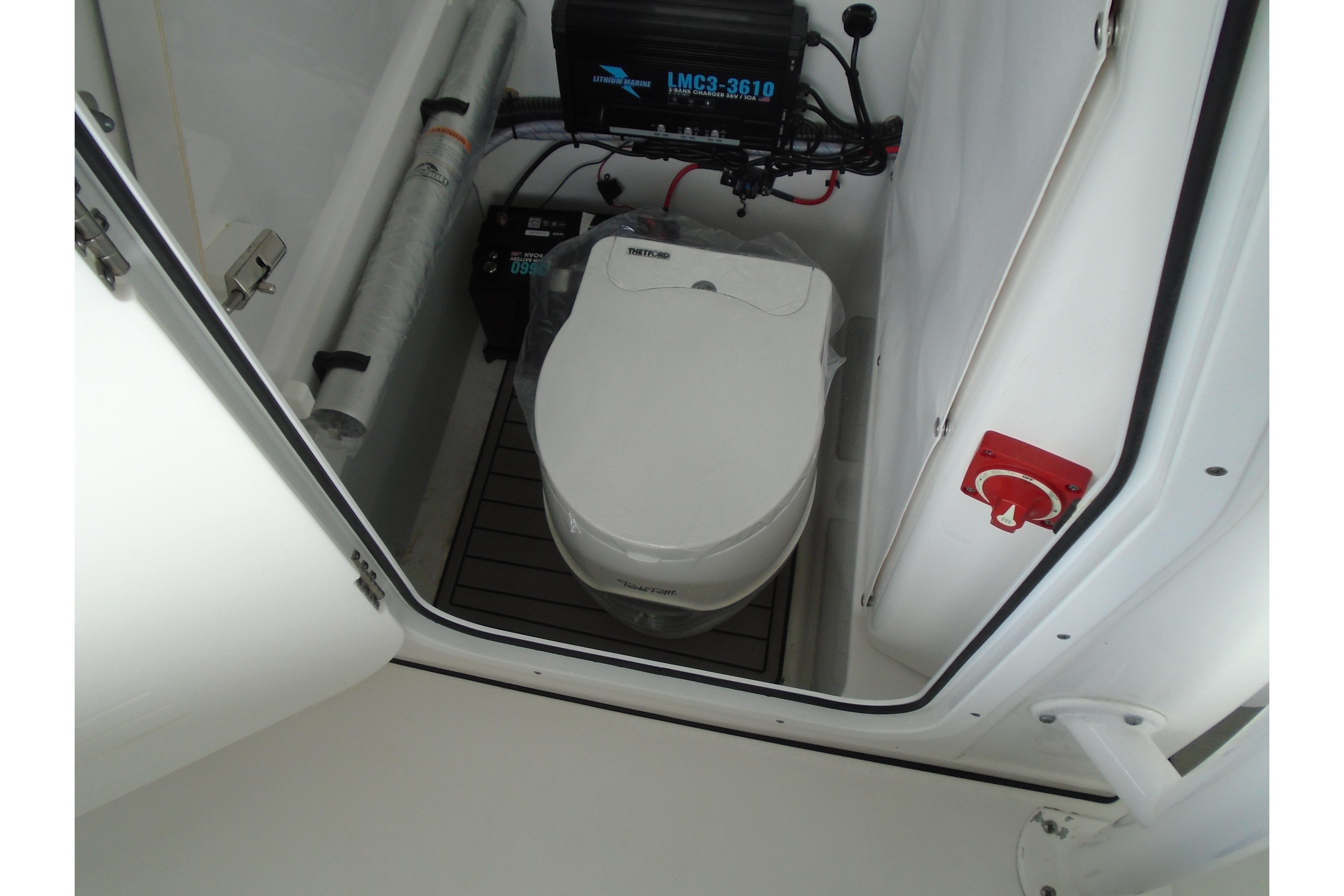 2022 Sportsman Heritage 241 Center Console boat interior with marine toilet and equipment.