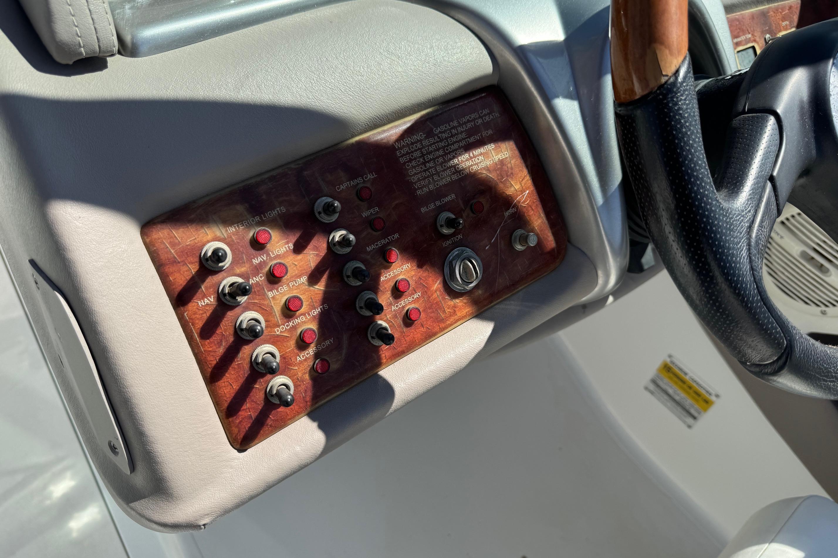 Control panel of a 2005 Cobalt 240 boat with switches and steering wheel.
