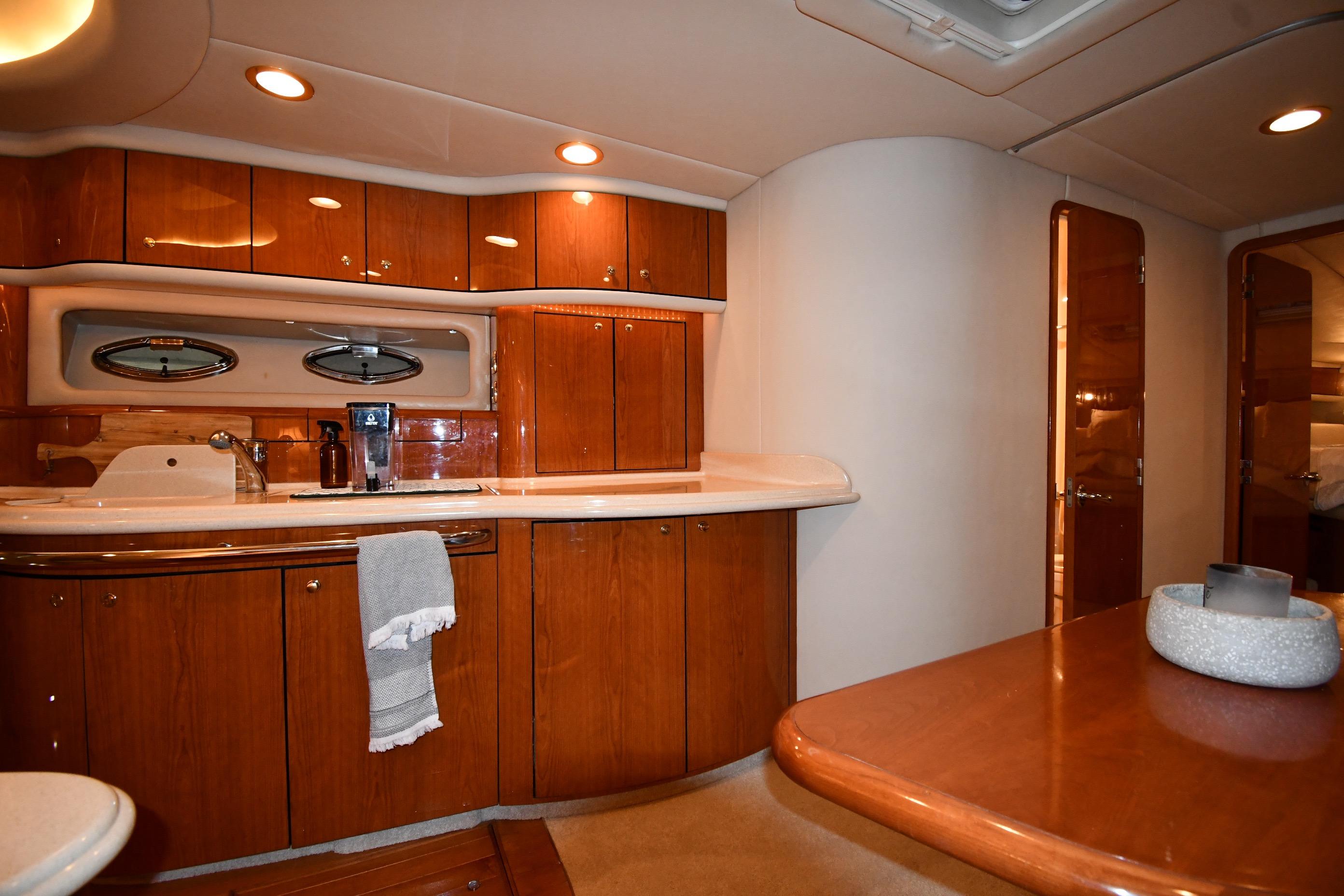 Luxurious interior of 2001 Sea Ray 540 Sundancer yacht with wooden cabinetry and modern amenities.