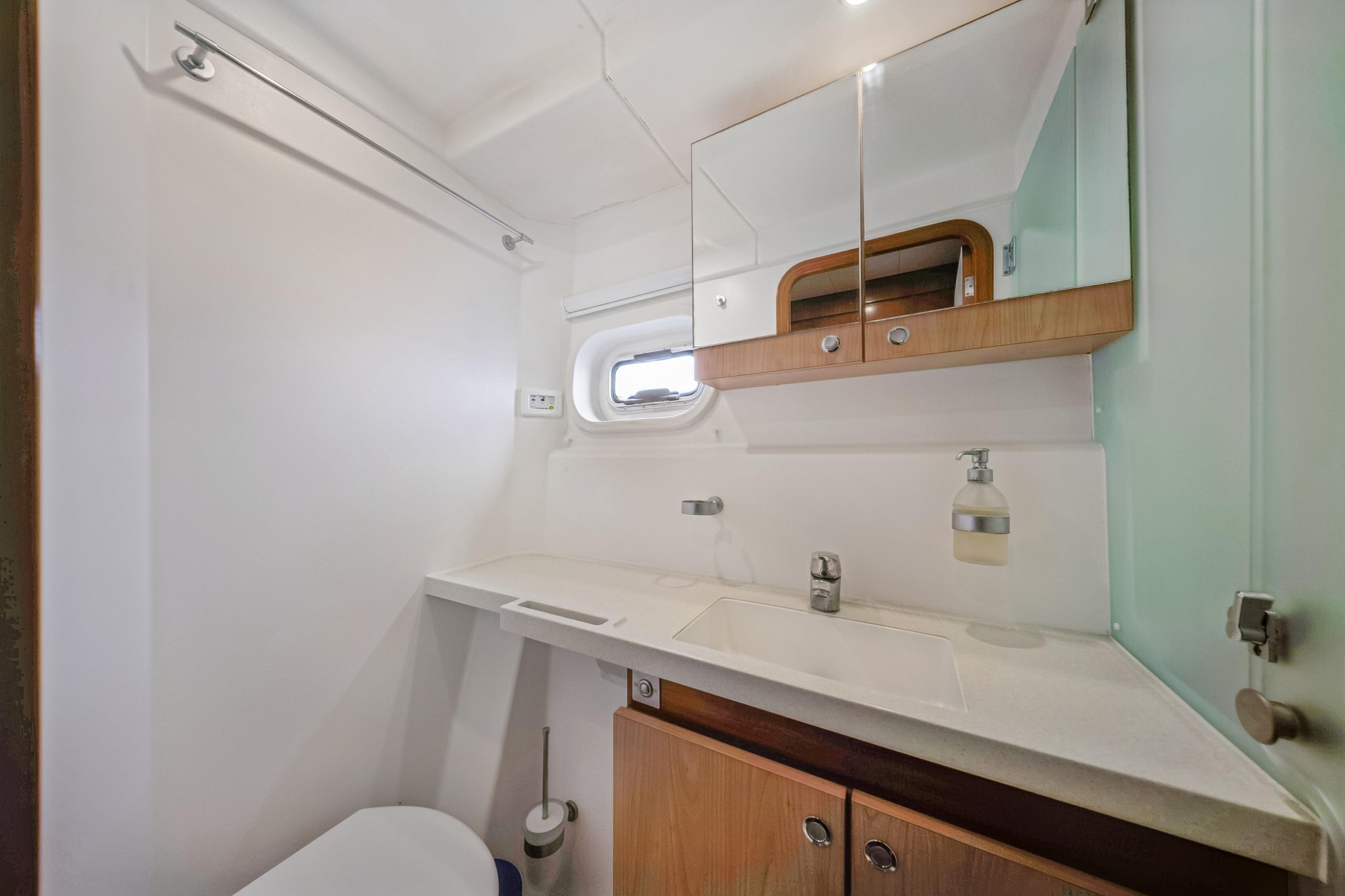 Bathroom interior of 2009 Catana 65 yacht with modern fixtures and wooden cabinetry.