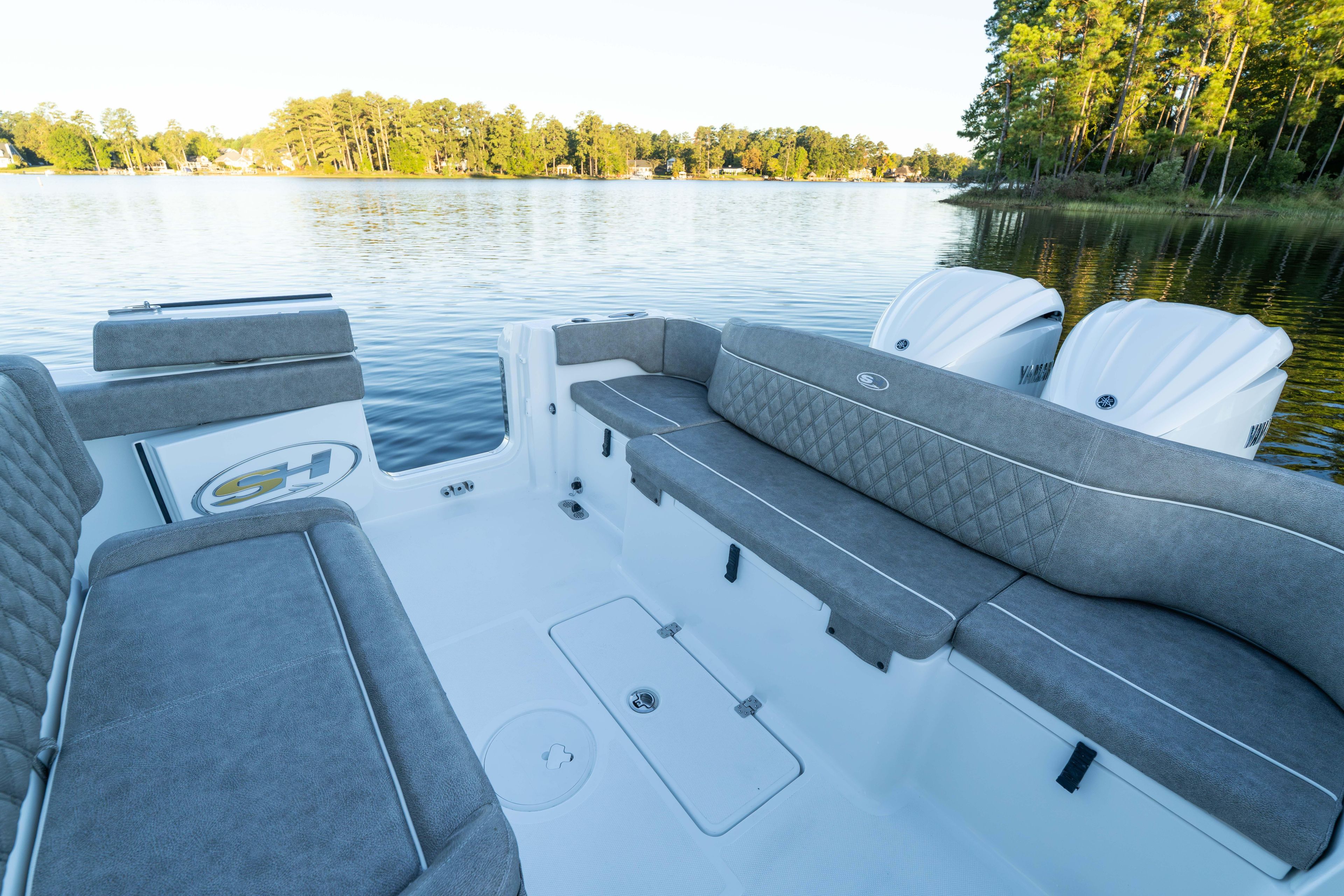 2026 Sea Hunt Ultra 275 Coffin Box boat interior with gray seating on a serene lake.
