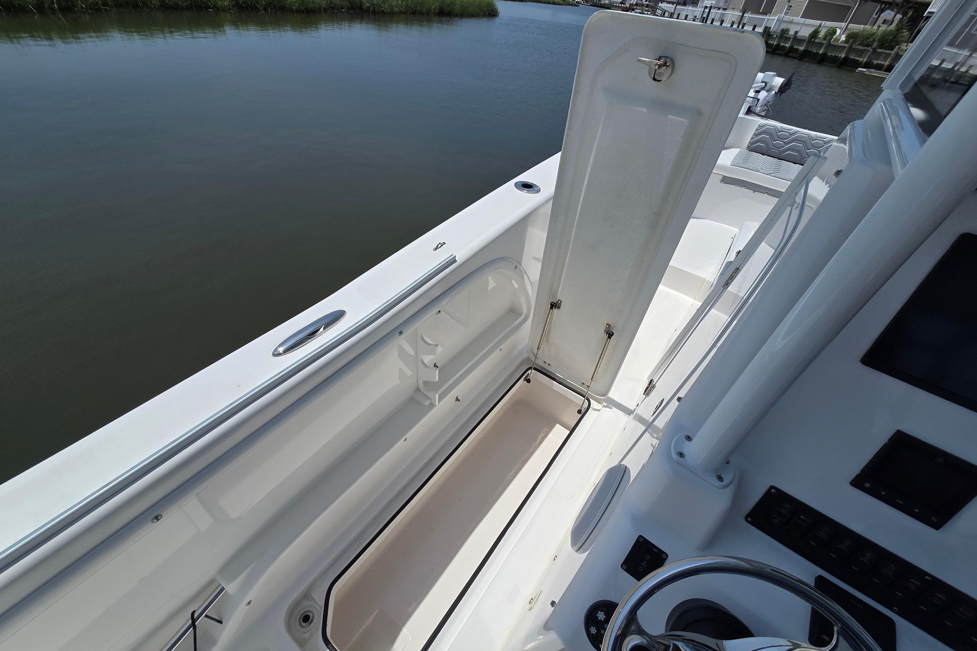 2021 Twin Vee 280 GFX CC boat interior with open storage compartment by the water.