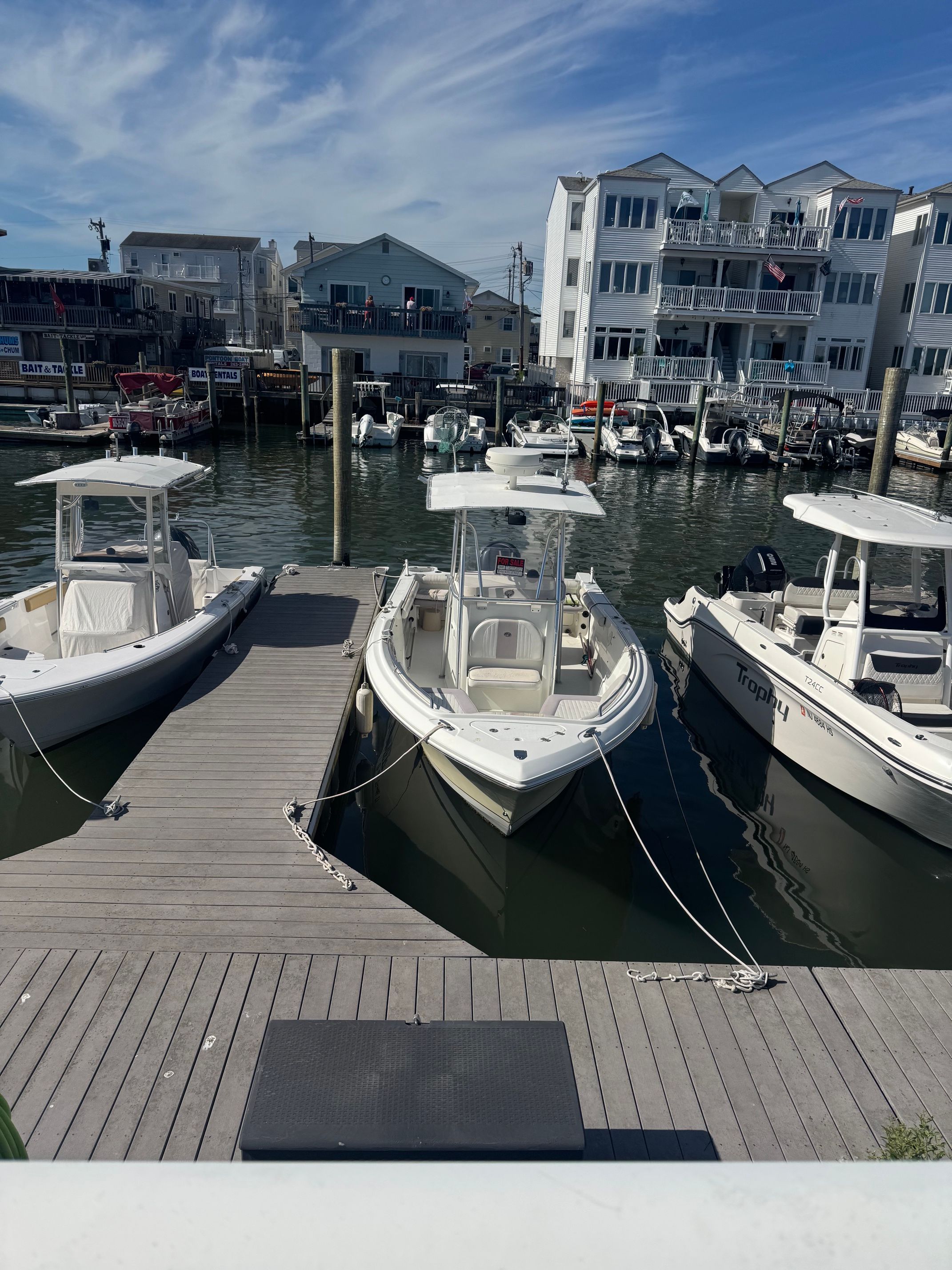 Boats docked, Sailfish 2360 CC, 2006, with cityscape background.