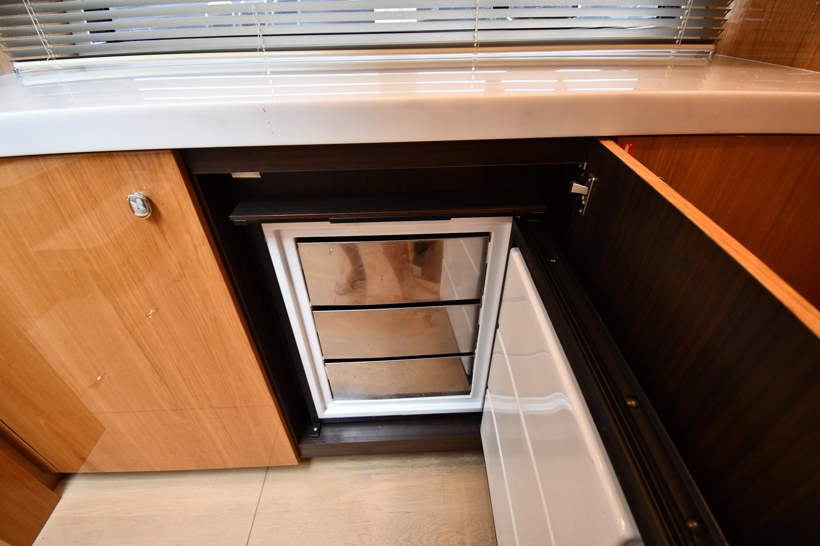 2024 Fairline G50 Targa yacht interior with open cabinet and mini fridge.