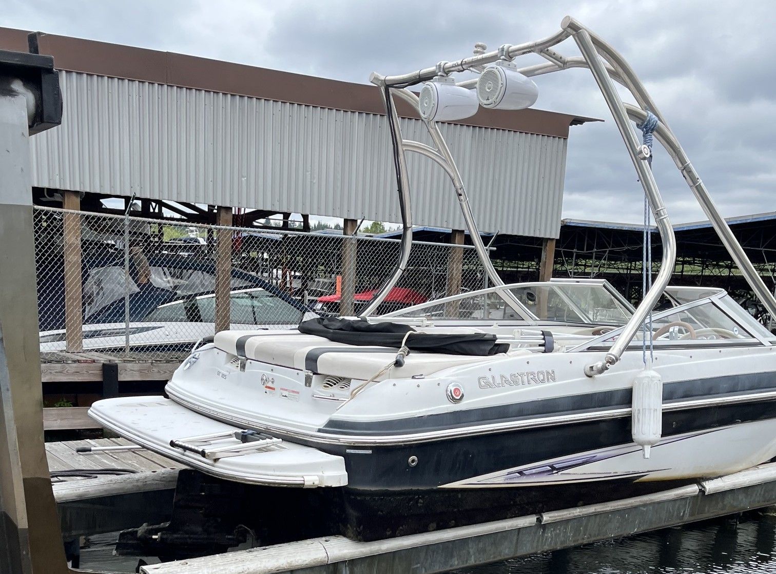 A 2011 Glastron GT 185 docked. It features a sleek white and black hull.