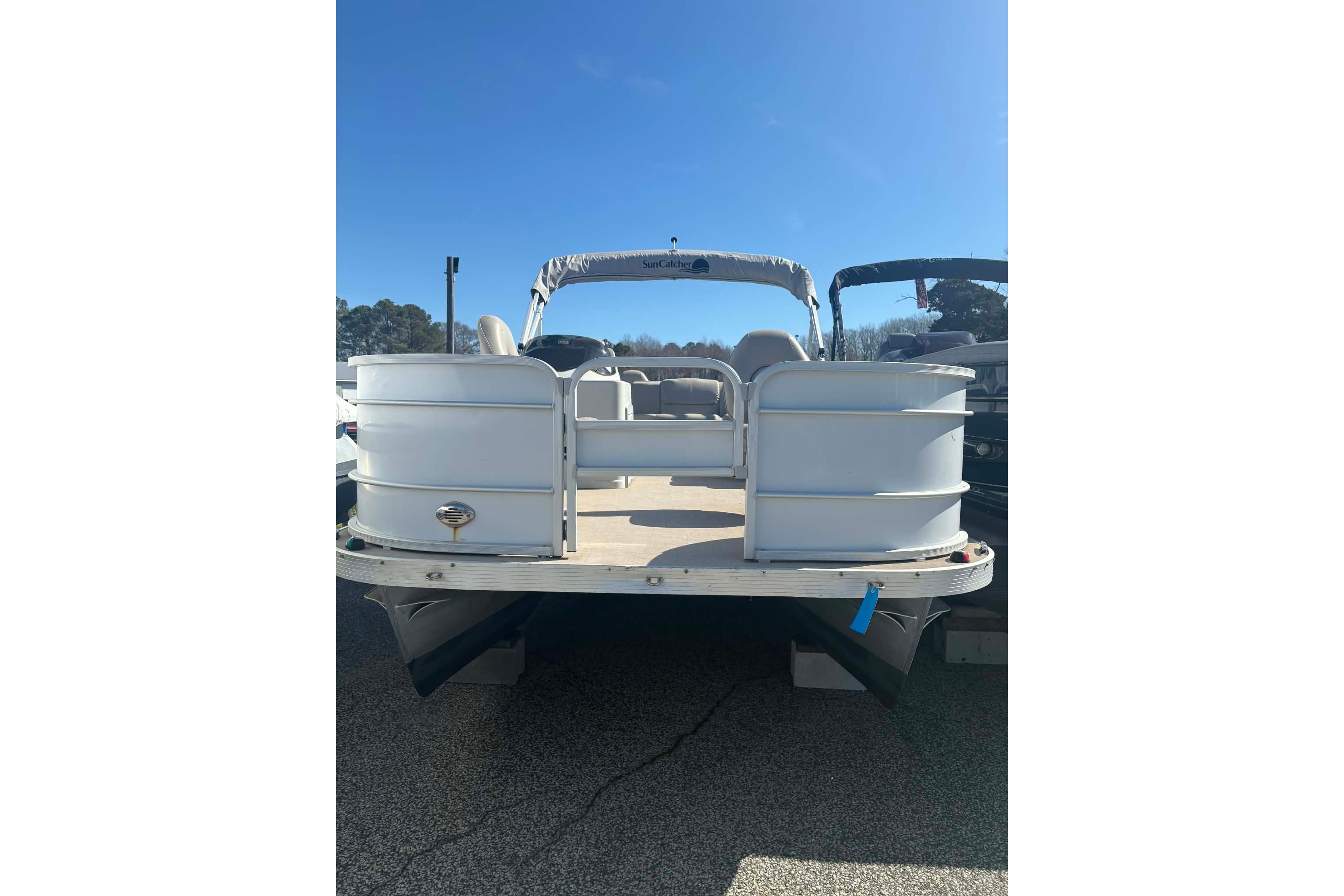 2017 G3 pontoon boat with canopy, docked under clear blue sky.