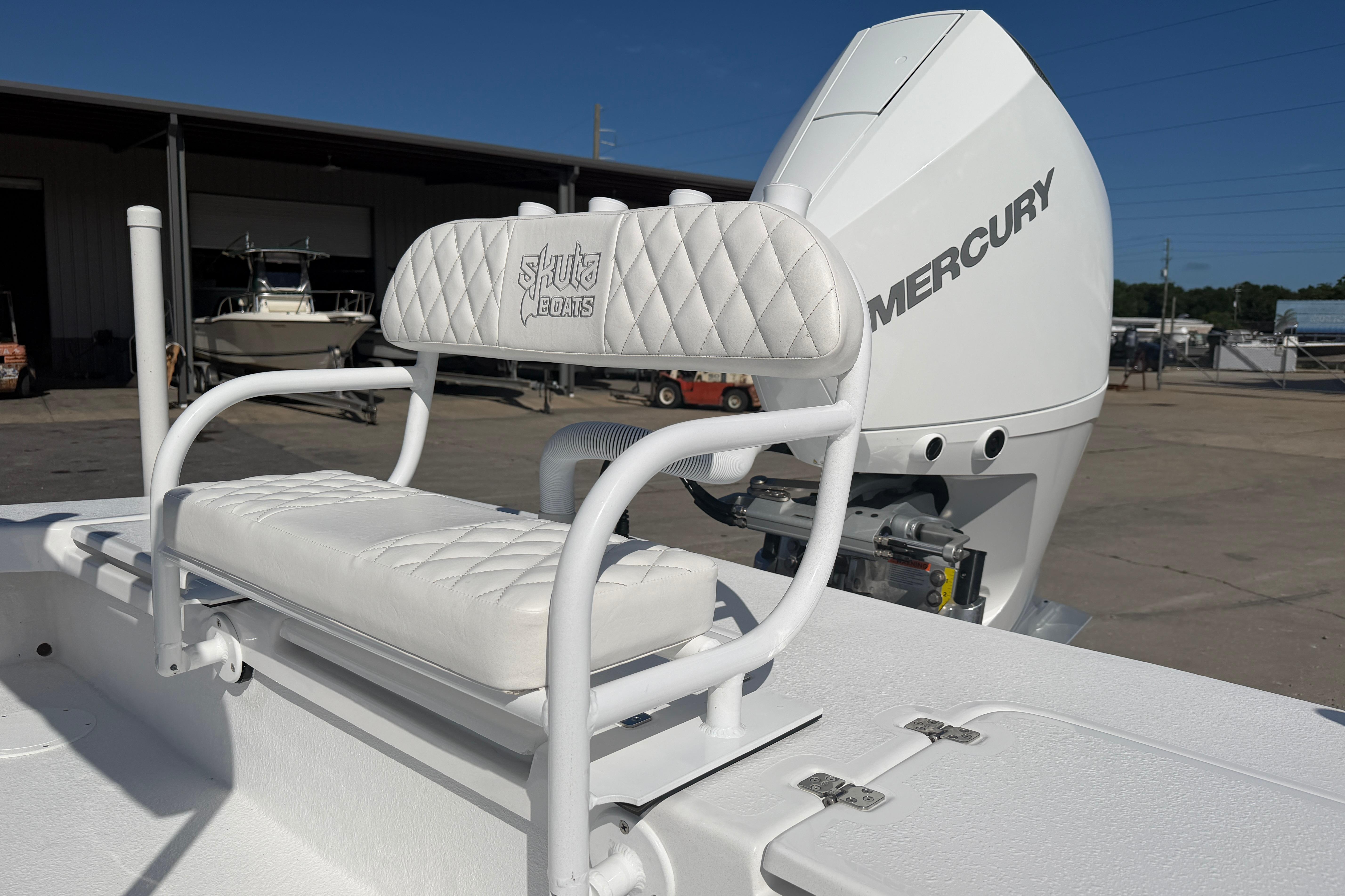2026 Skuta 24 Cat boat with Mercury engine, featuring white cushioned seating.