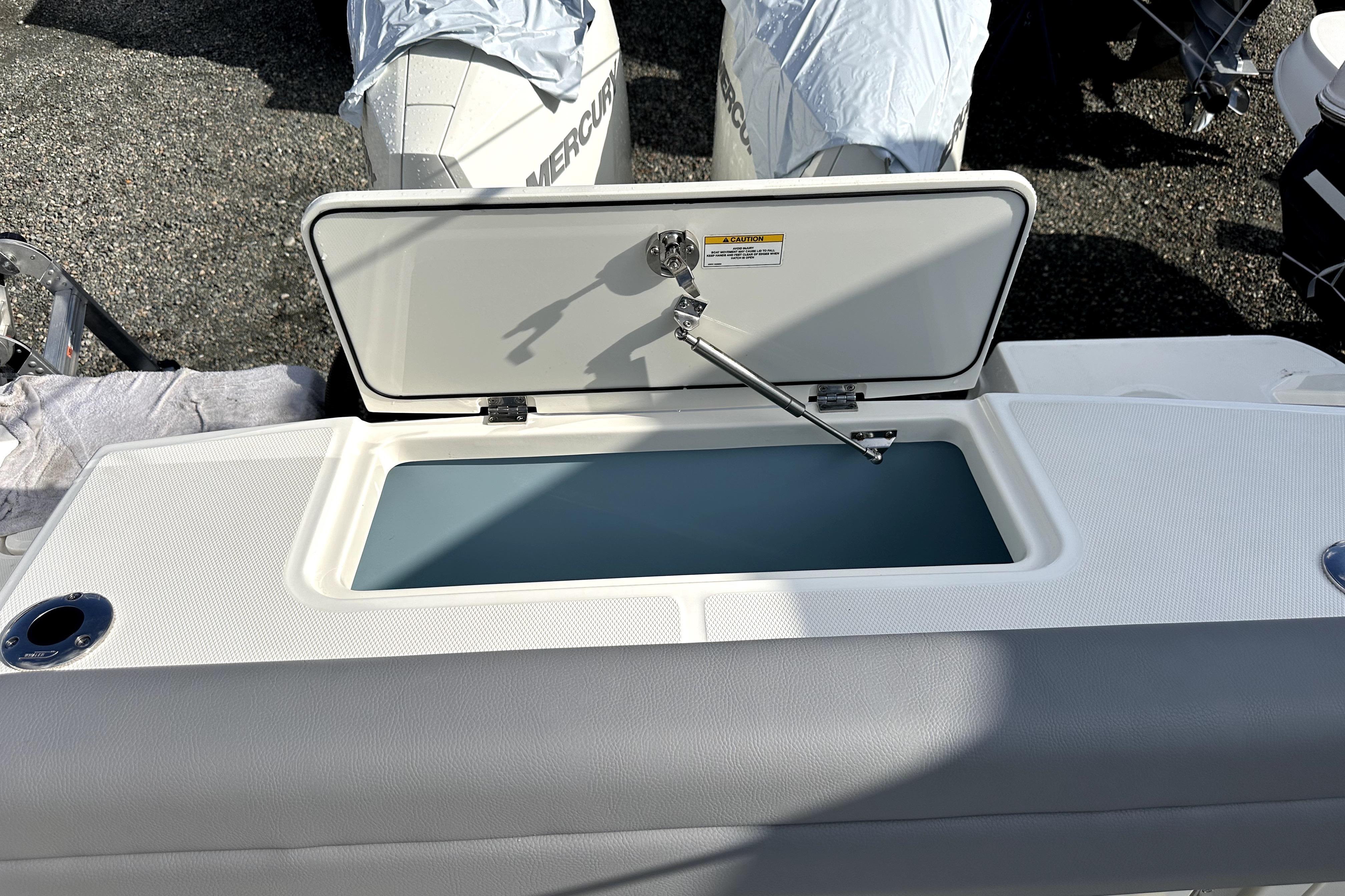 2023 Boston Whaler OUTRAGE boat with open storage compartment, showcasing sleek design.