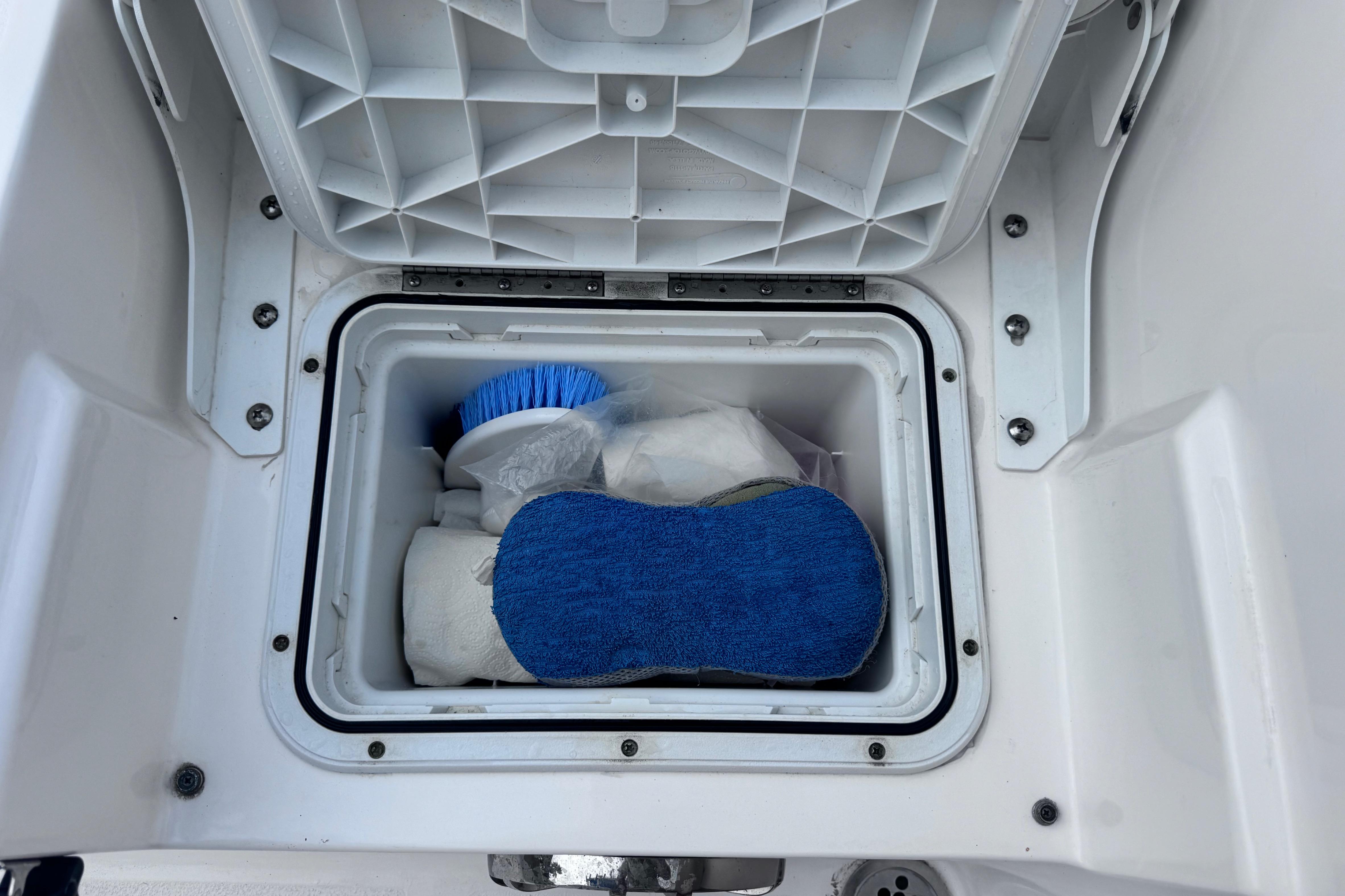 Storage compartment on 2018 Sea Fox 206 Commander boat with cleaning supplies.