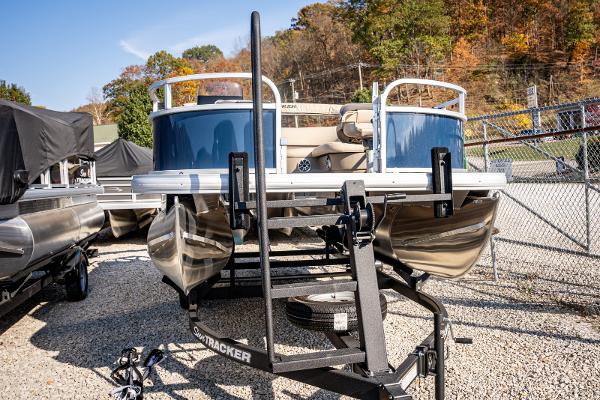 2025 Sun Tracker Bass Buggy 16 DLX pontoon boat on trailer, parked outdoors.