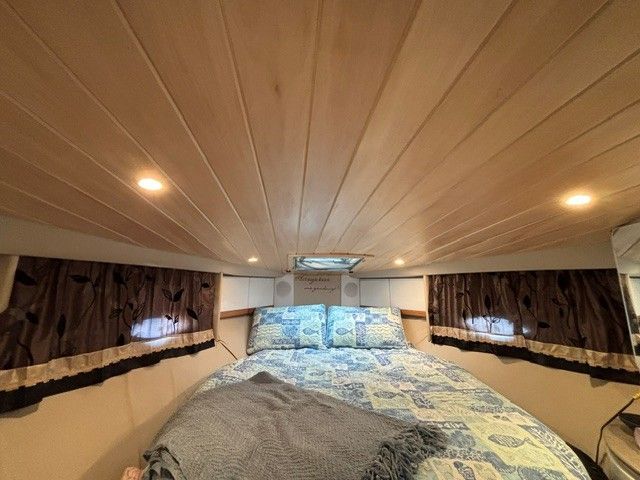 Interior of a 1998 Formula 41 Performance Cruiser with a cozy bed and wooden ceiling.