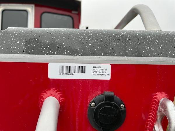 2024 Spartan 220 Maximus boat, red exterior, close-up of label and railing.