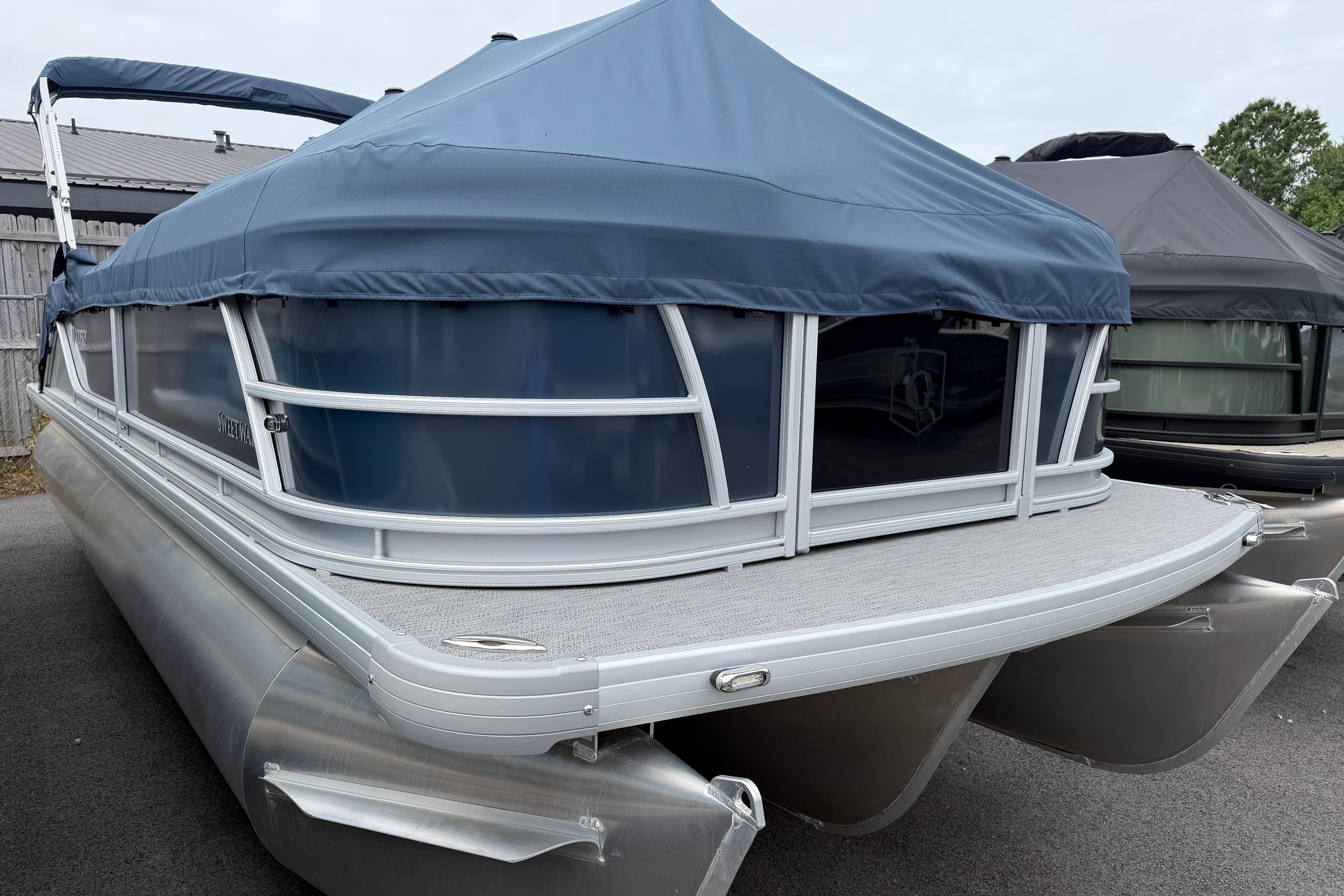 2026 Godfrey SW 2286 SFLC pontoon boat with blue cover, docked outdoors.