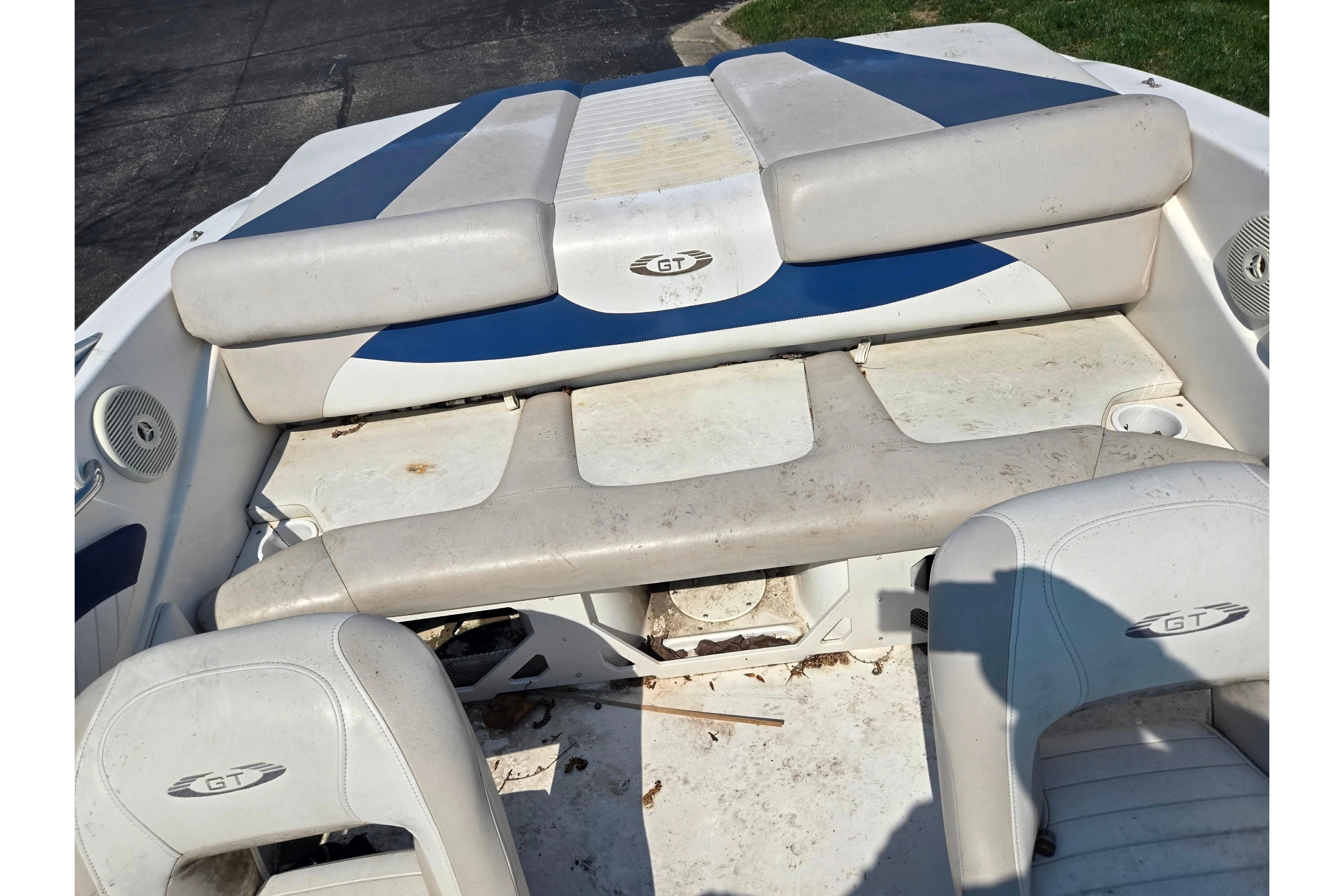 2007 Glastron GT 185 boat interior with white and blue seating, showing wear.