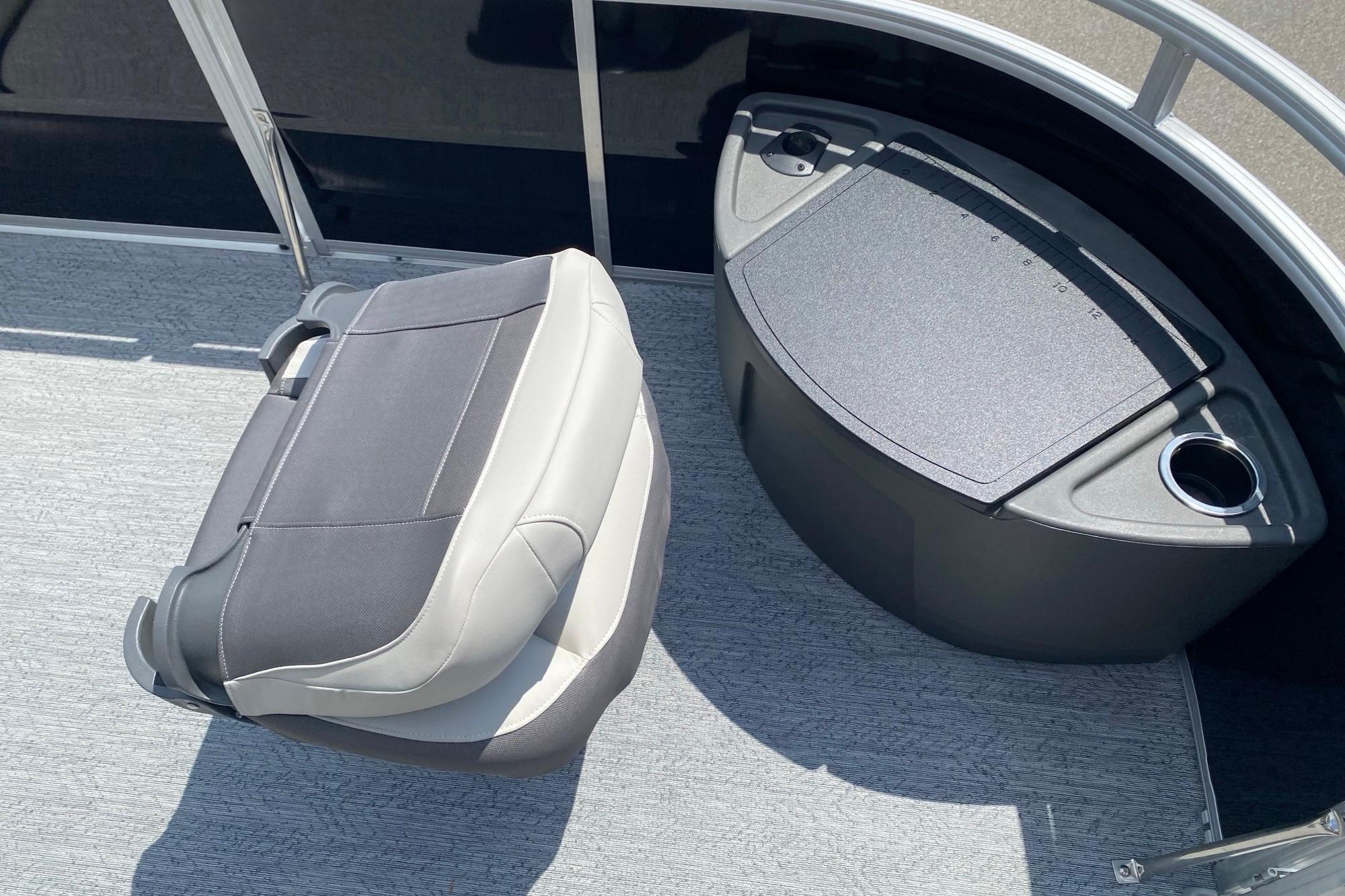 2026 Sun Tracker Fishin' Barge 20 DLX interior with seating and storage compartment.