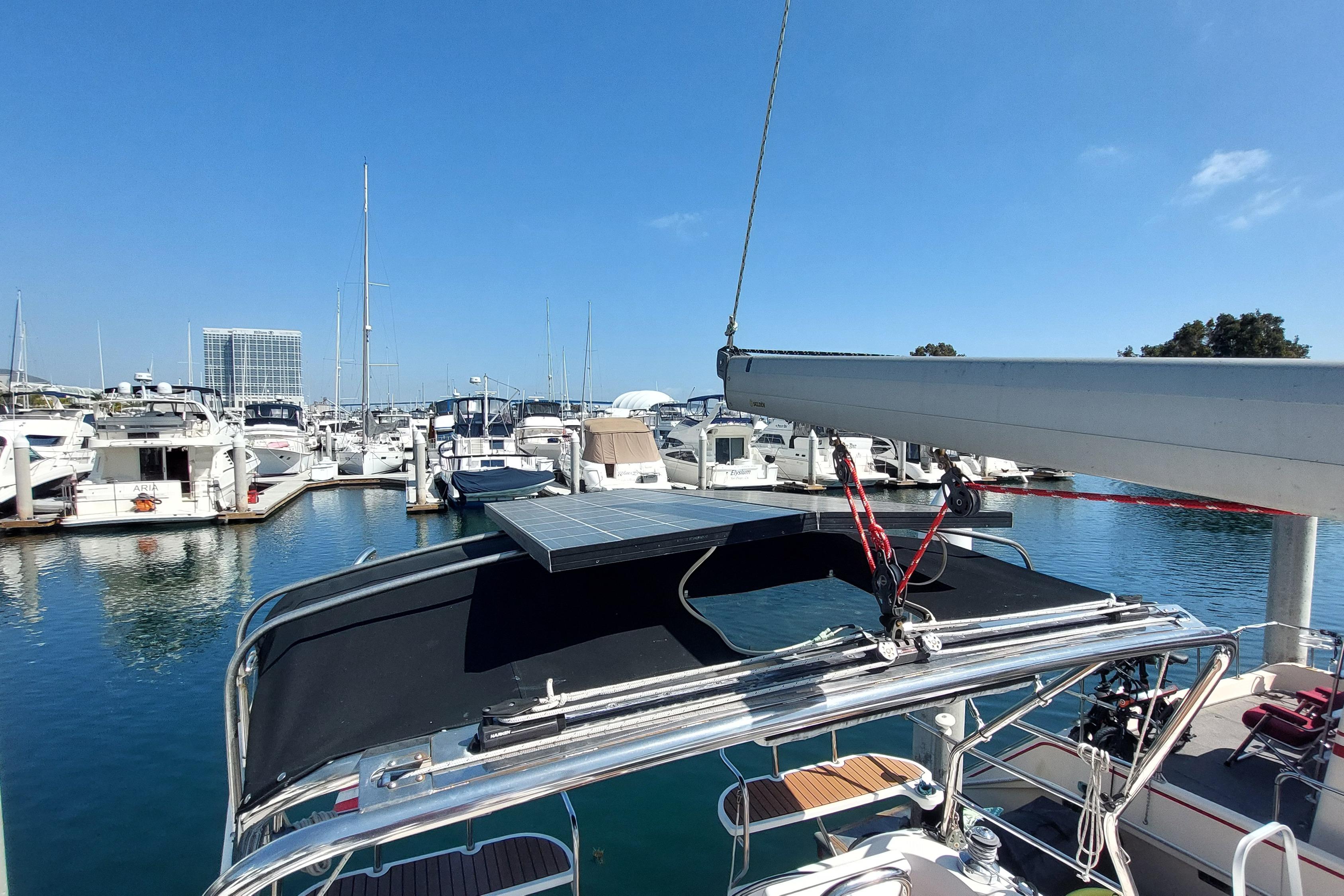 2005 Hunter 38 sailboat docked in marina with solar panel and clear blue sky.