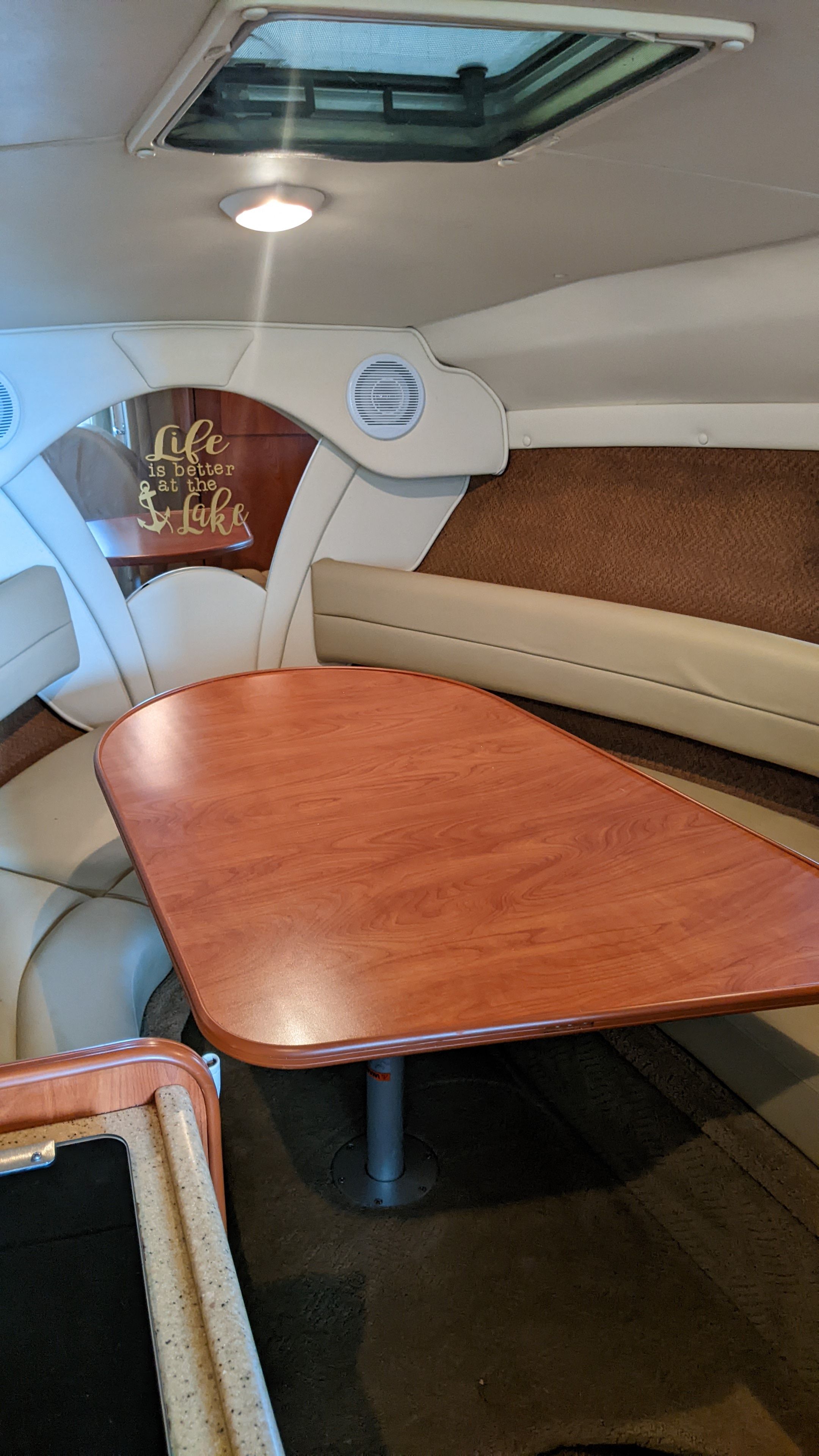 Interior of a 2006 Rinker 250 EC boat with wooden table.