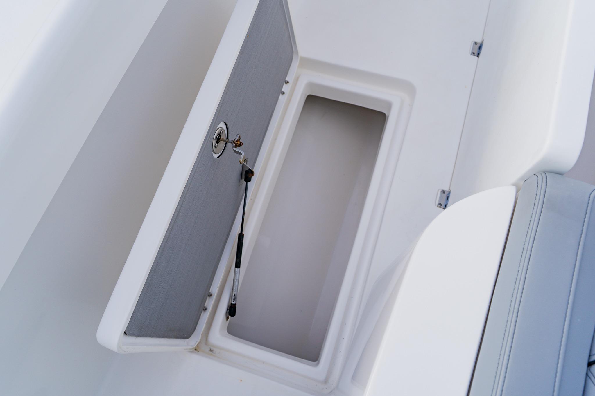 Open storage compartment on 2024 Orion 29CC boat, featuring a secure latch and hydraulic support.