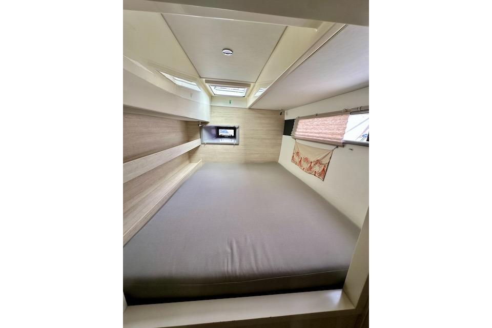 Interior cabin of a 2017 Leopard 40 catamaran, featuring a spacious bed and windows.