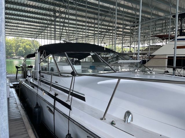 A 1989 Trojan 370 Express docked in a covered marina.
