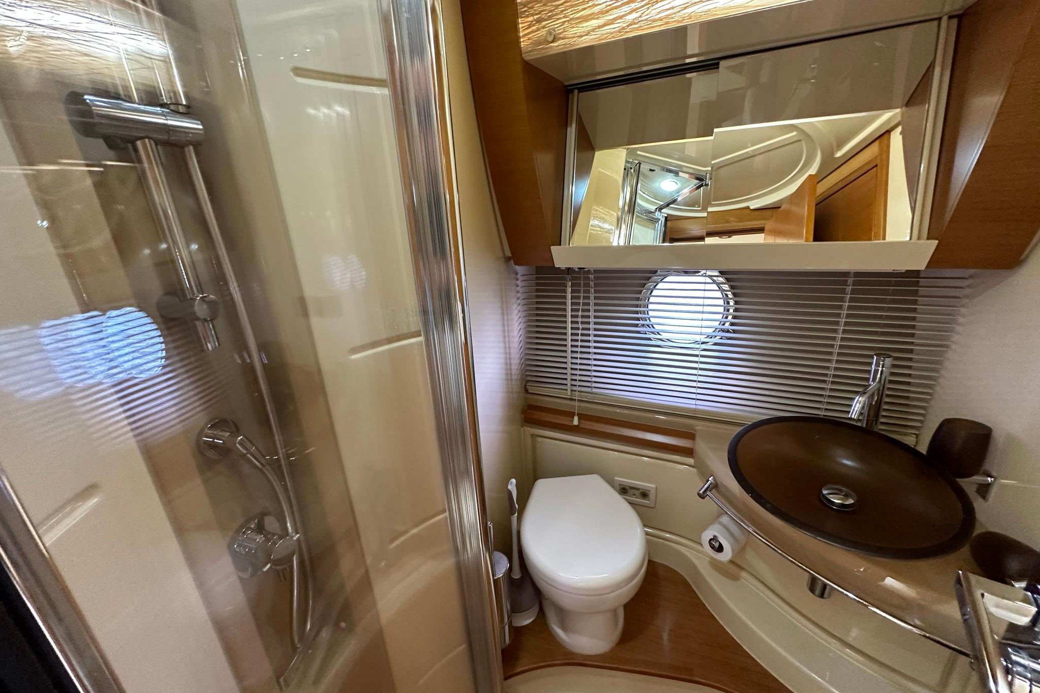 Luxurious bathroom in 2013 Azimut Fly 53 yacht with modern fixtures and porthole window.