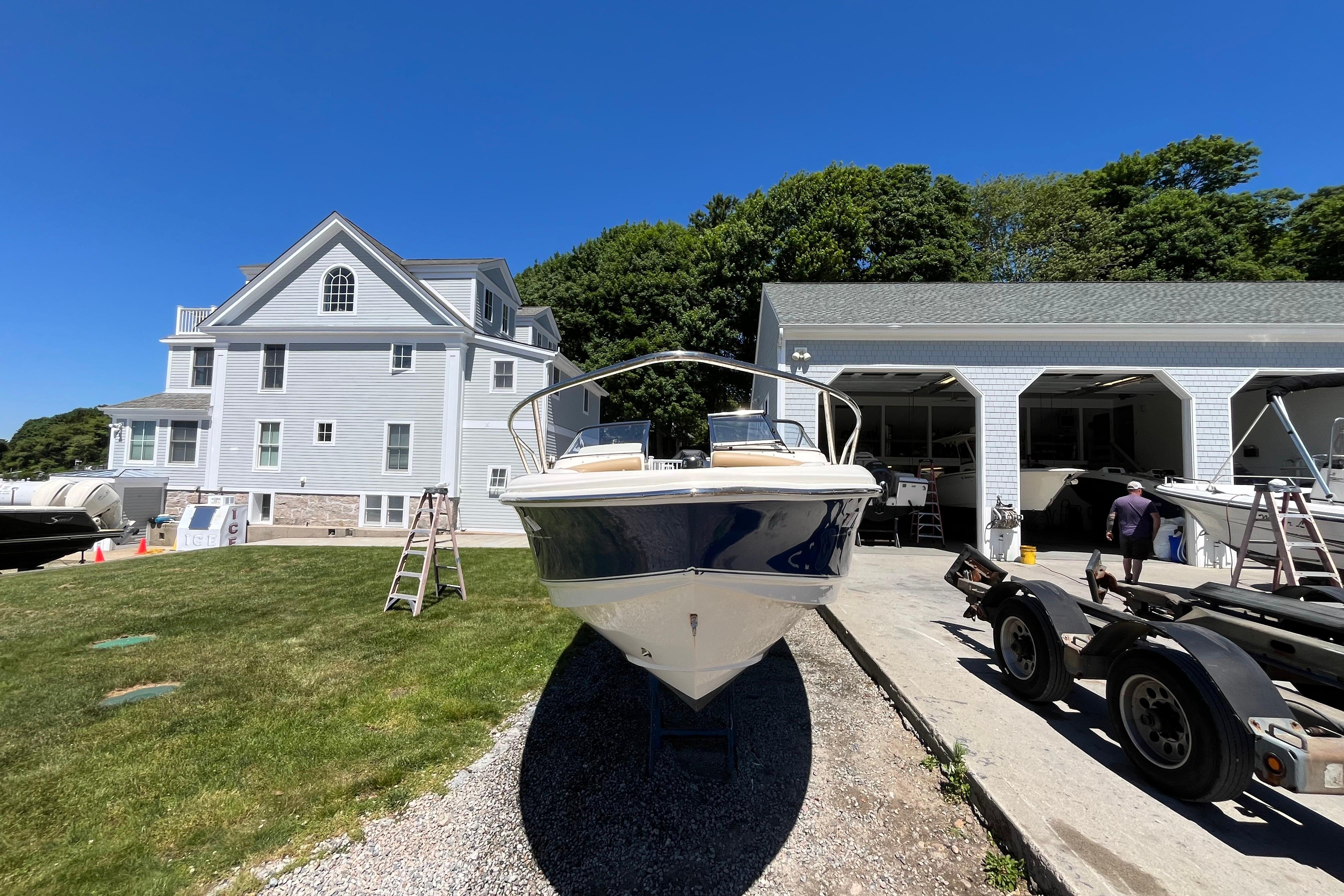 2017 Scout 210 Dorado boat on trailer near a large house and garage.