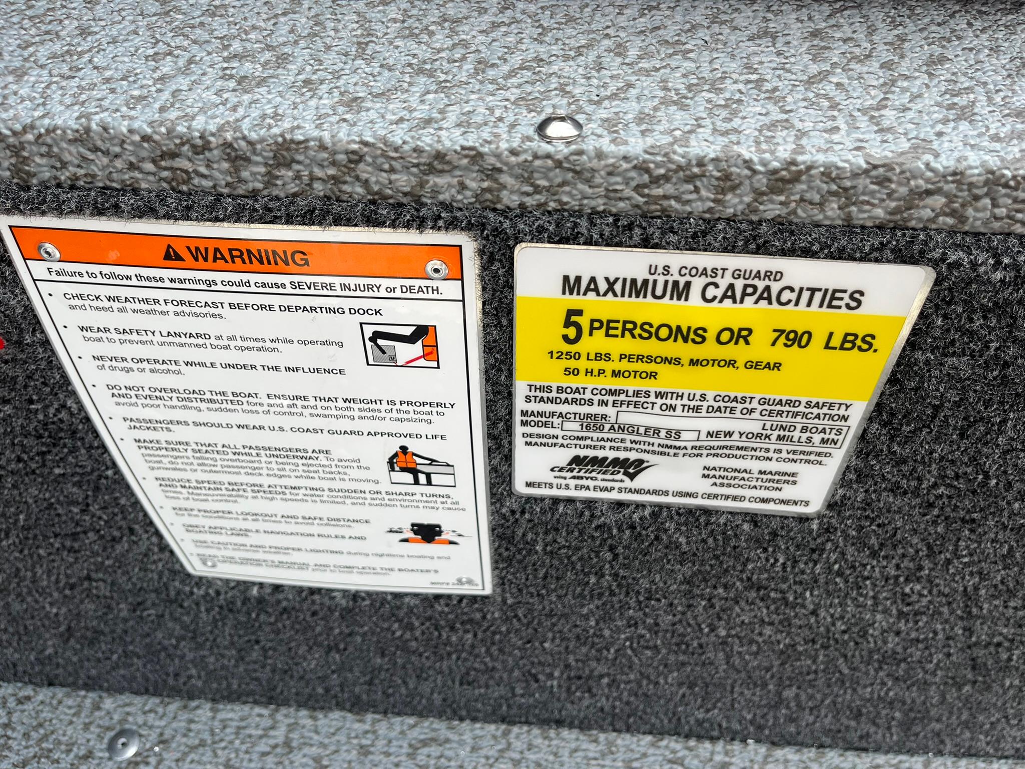 Warning and capacity labels on 2026 Lund 1650 Angler SS boat interior.