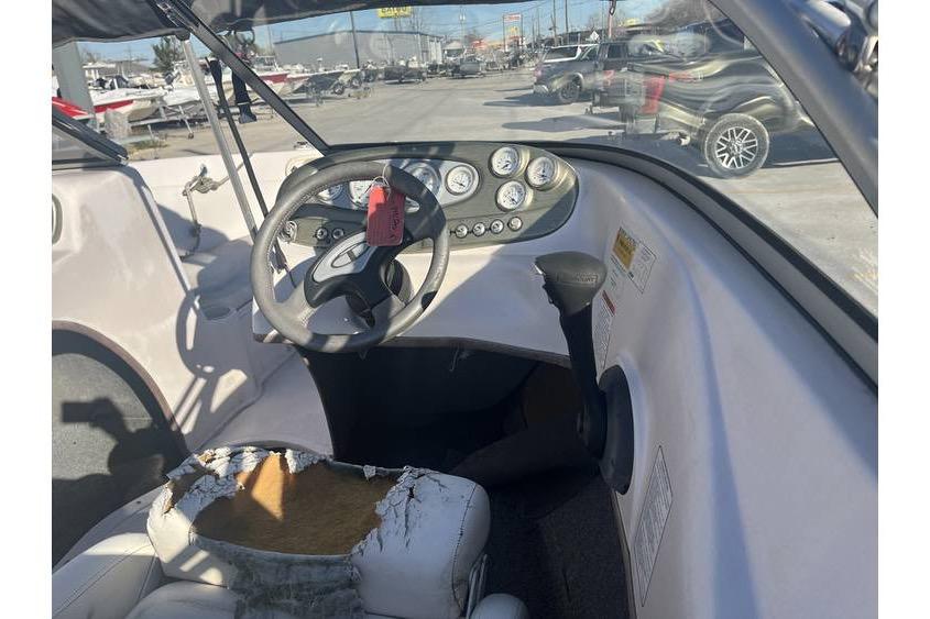 2006 Tahoe 206 boat interior with worn seat and steering wheel.