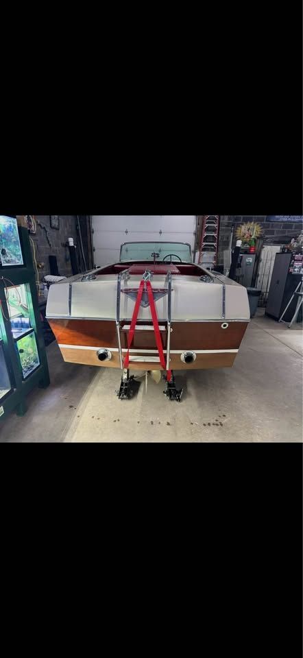 Rear view of a 1965 Century Sabre boat in a garage.