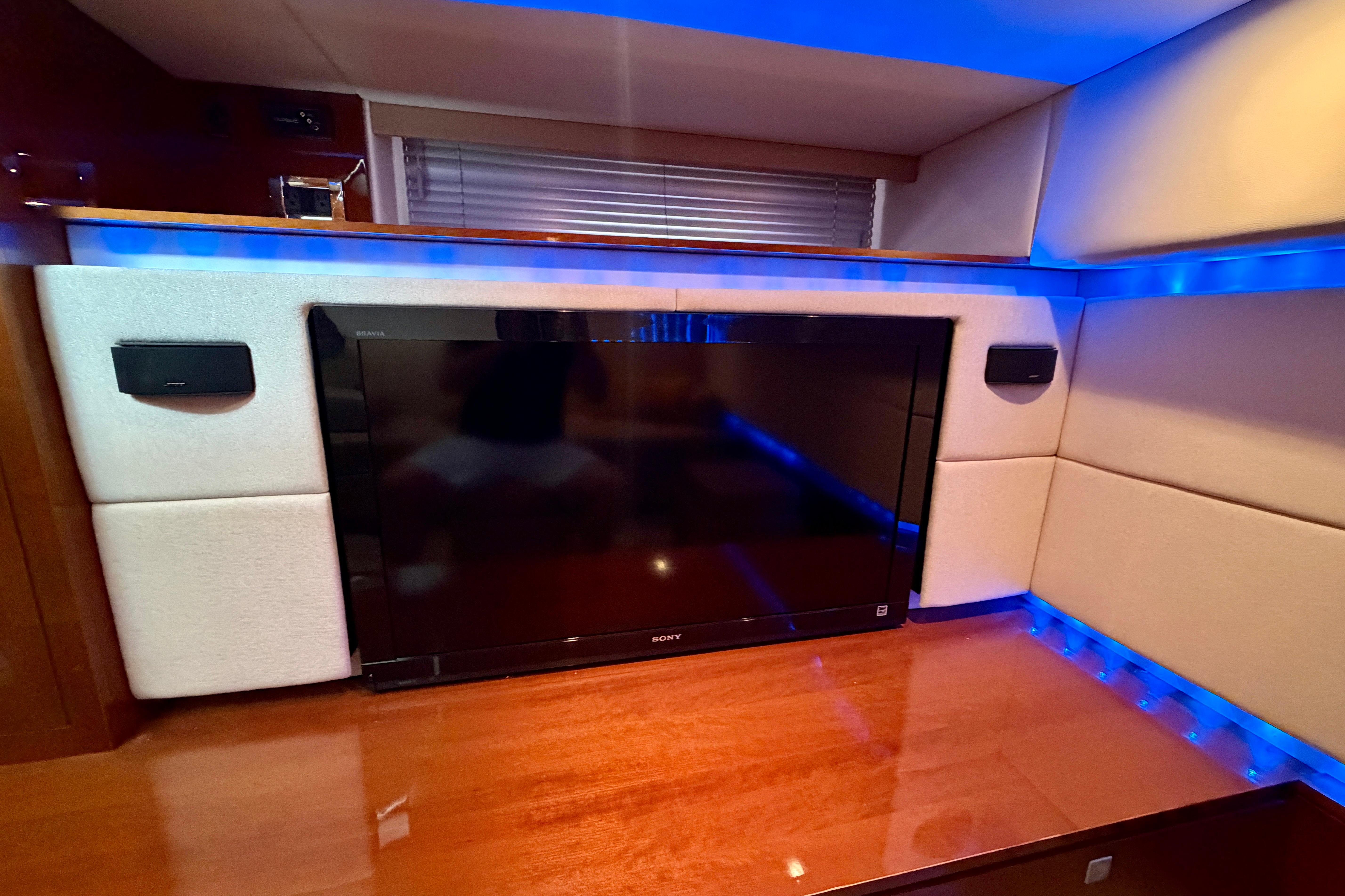 Luxurious interior of 2012 Sea Ray 450 Sundancer with TV and ambient blue lighting.