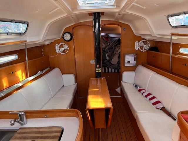Interior of 2007 Beneteau First 36.7 sailboat with wood finish and white seating.