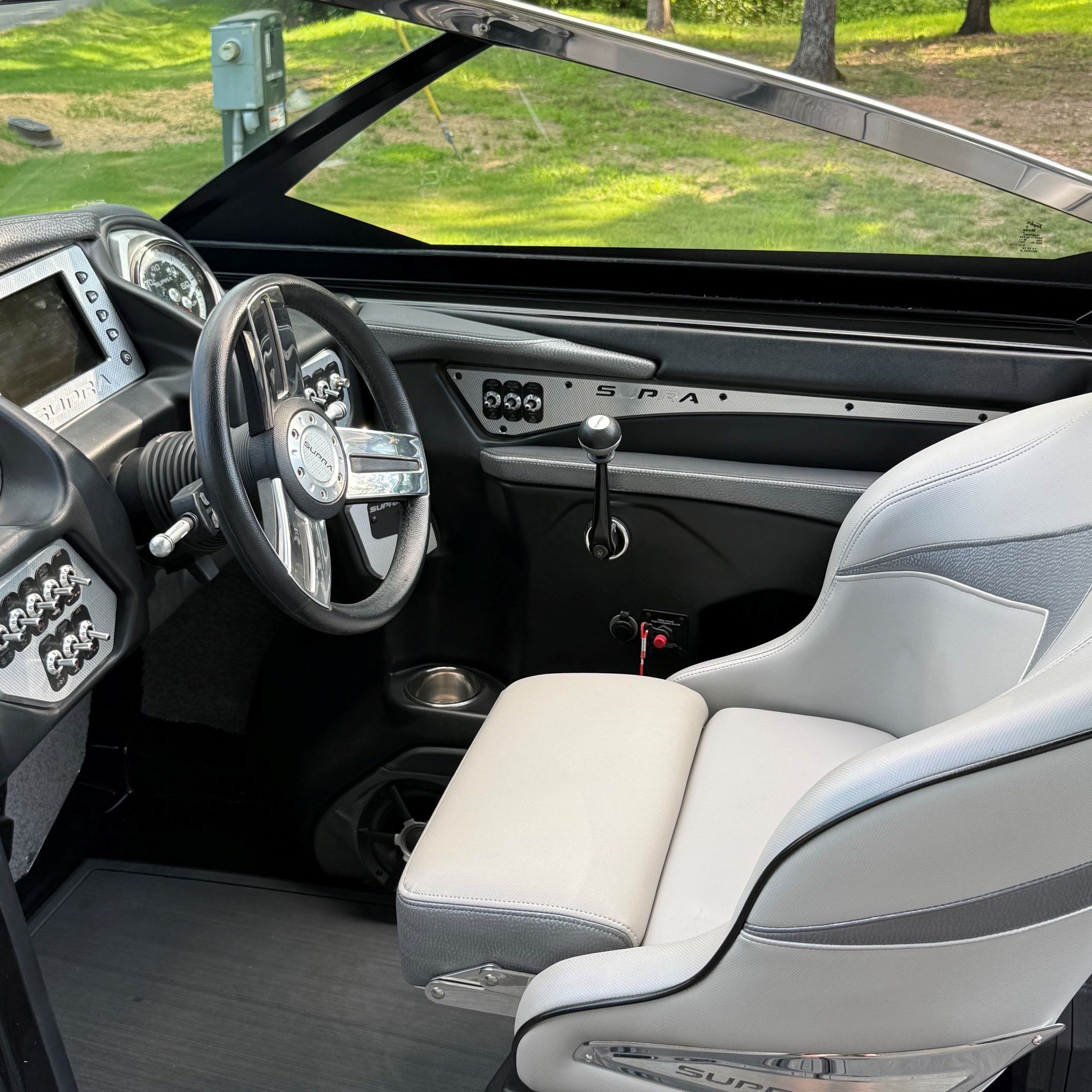 Interior of a 2014 Supra SC350 with a gray steering wheel and white seats.