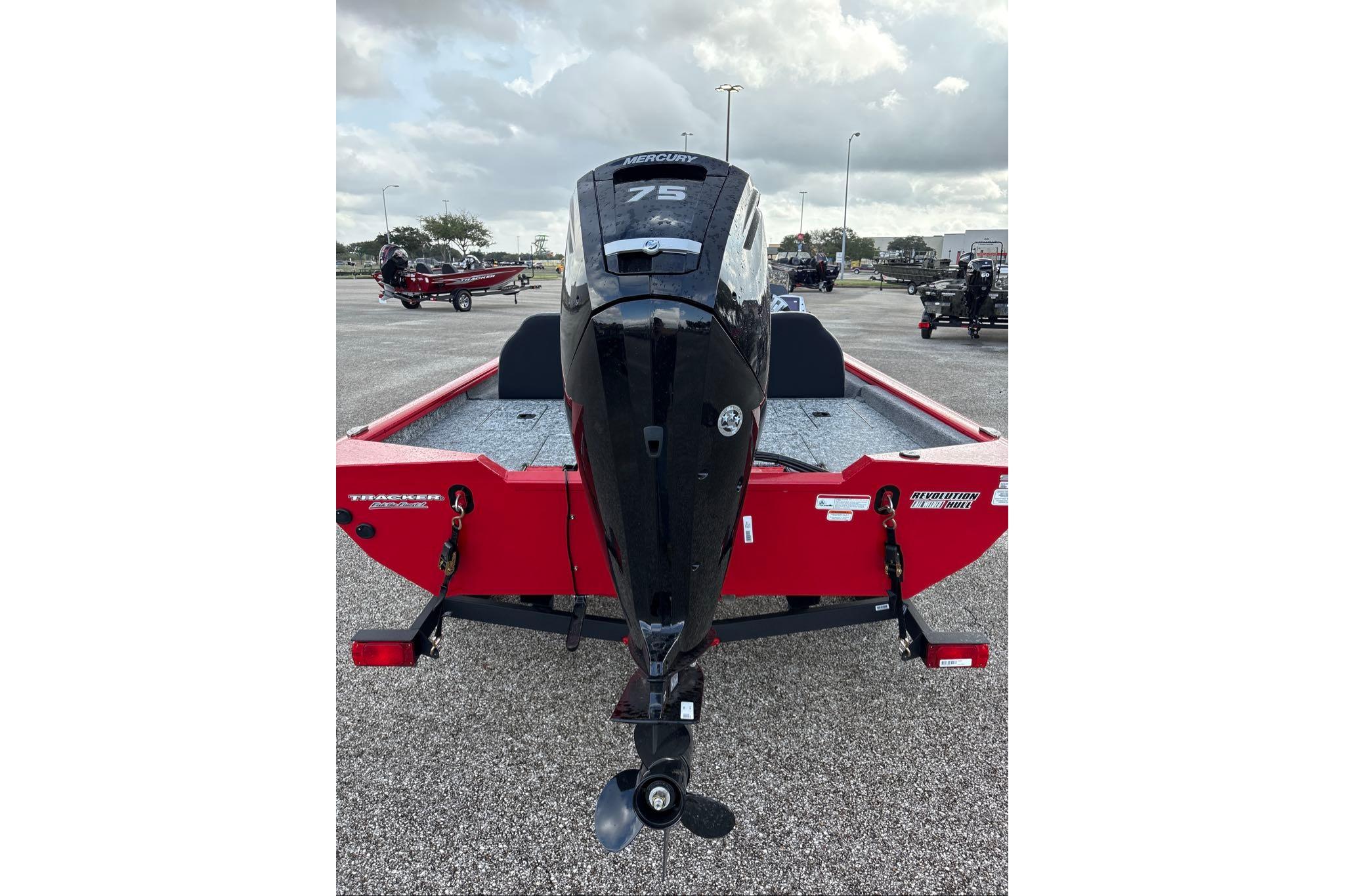 2026 Tracker Pro Team 175 boat, red exterior, parked on asphalt, rear view with motor.