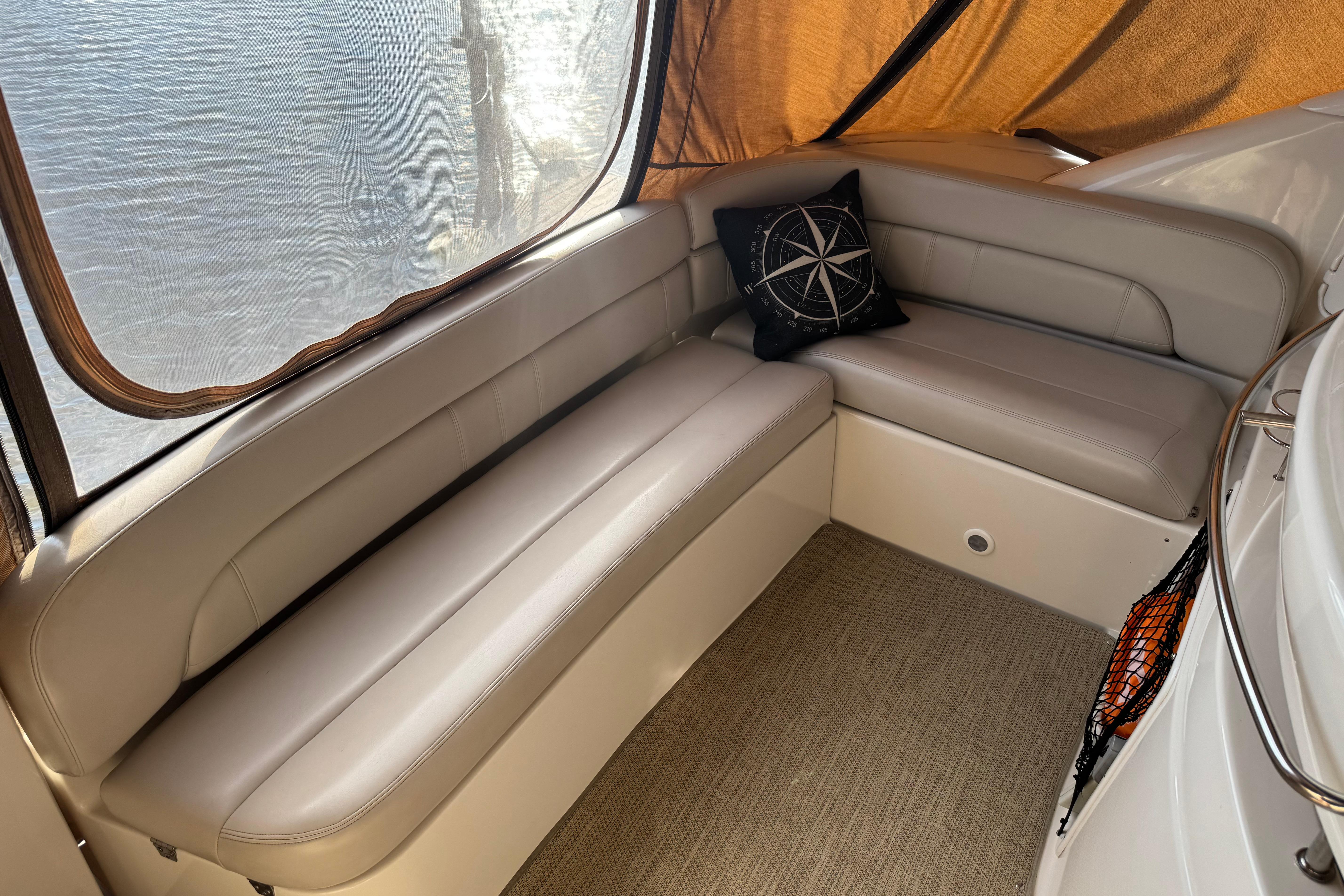 Luxurious seating area on a 2007 Regal Commodore 3860 yacht with nautical-themed decor.
