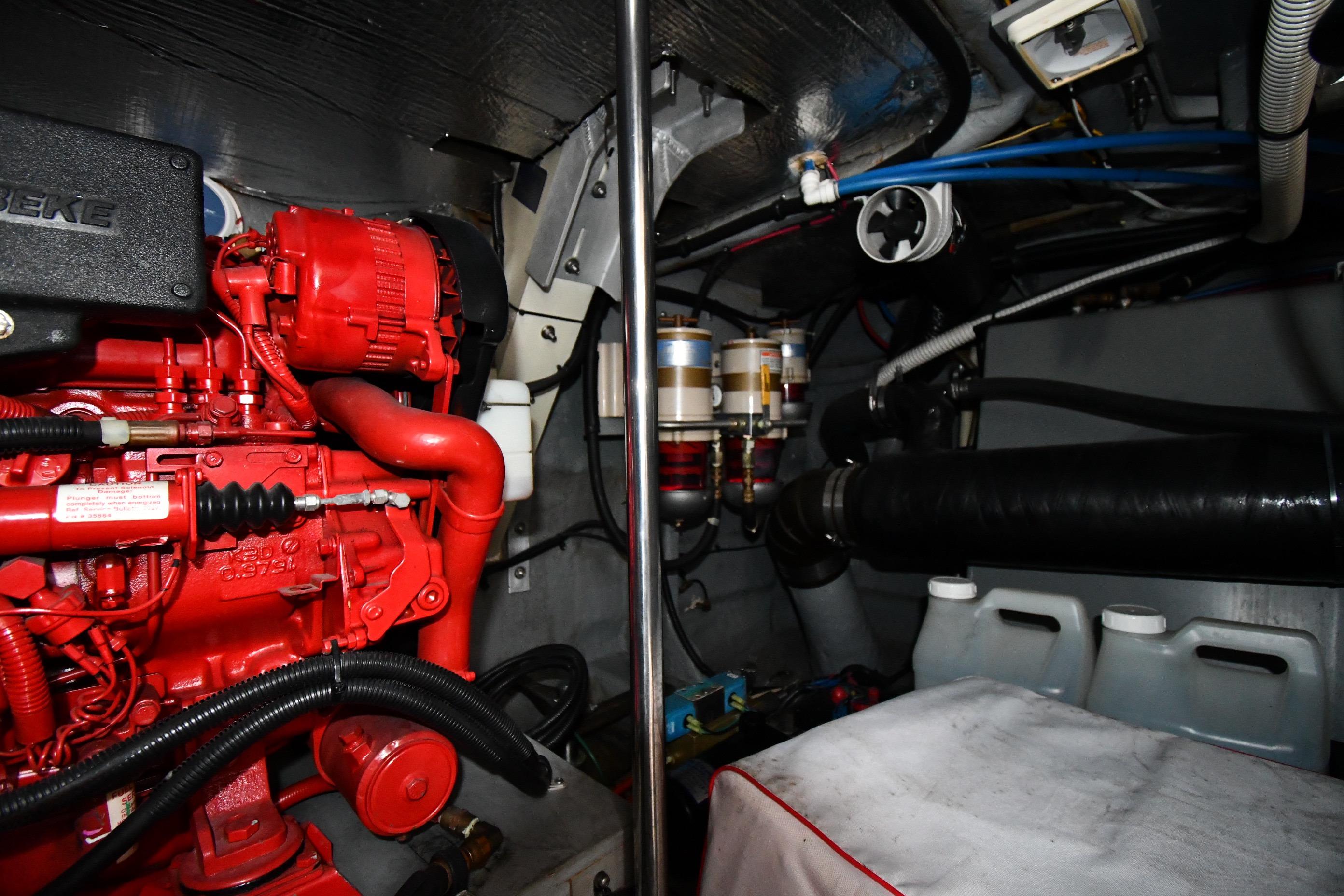 Engine room of 2000 Sea Ray 460 Sundancer with red engine components and fuel filters.