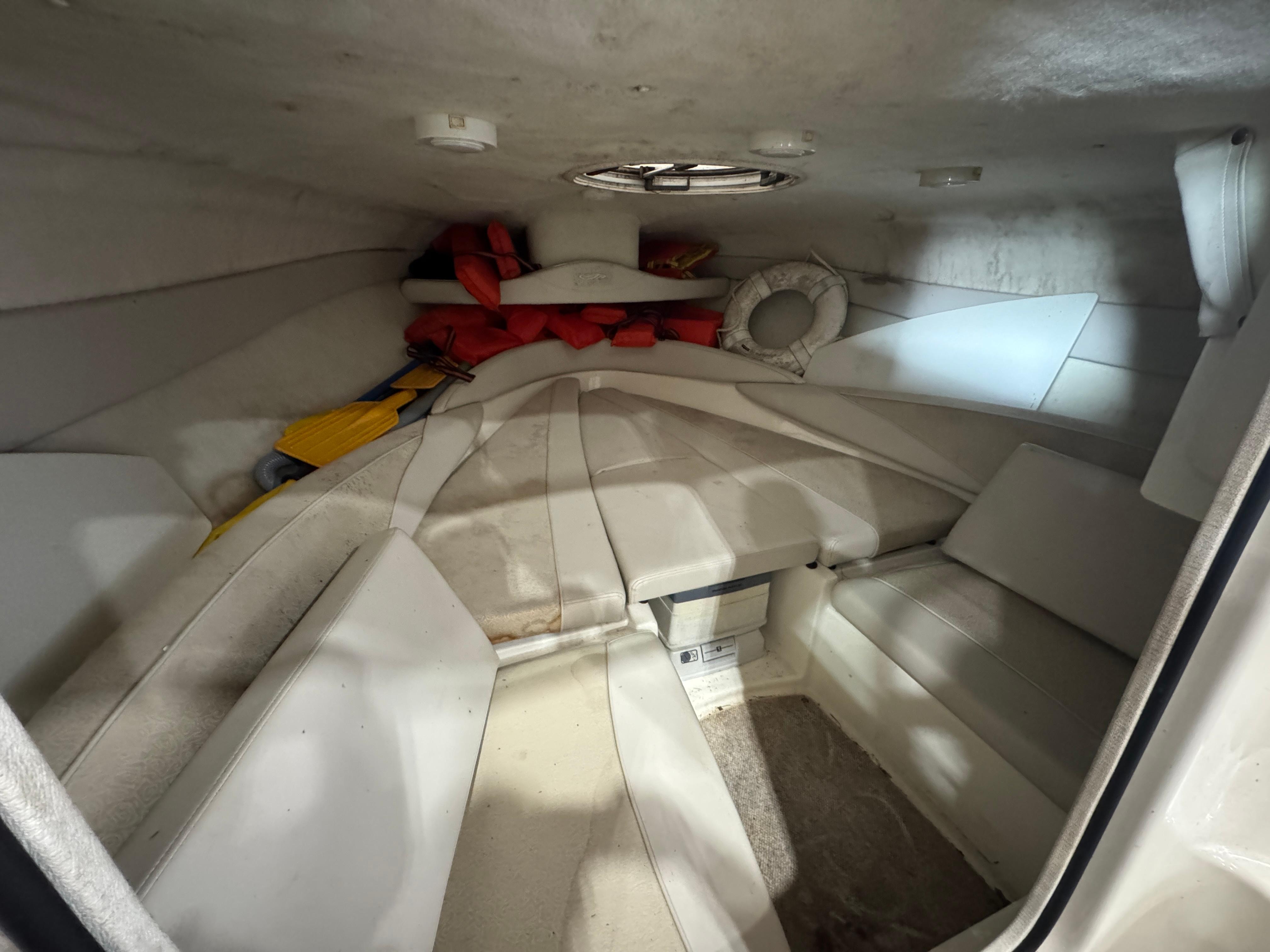 2004 Maxum 2100 SC boat cabin interior with seating, life jackets, and a life preserver.