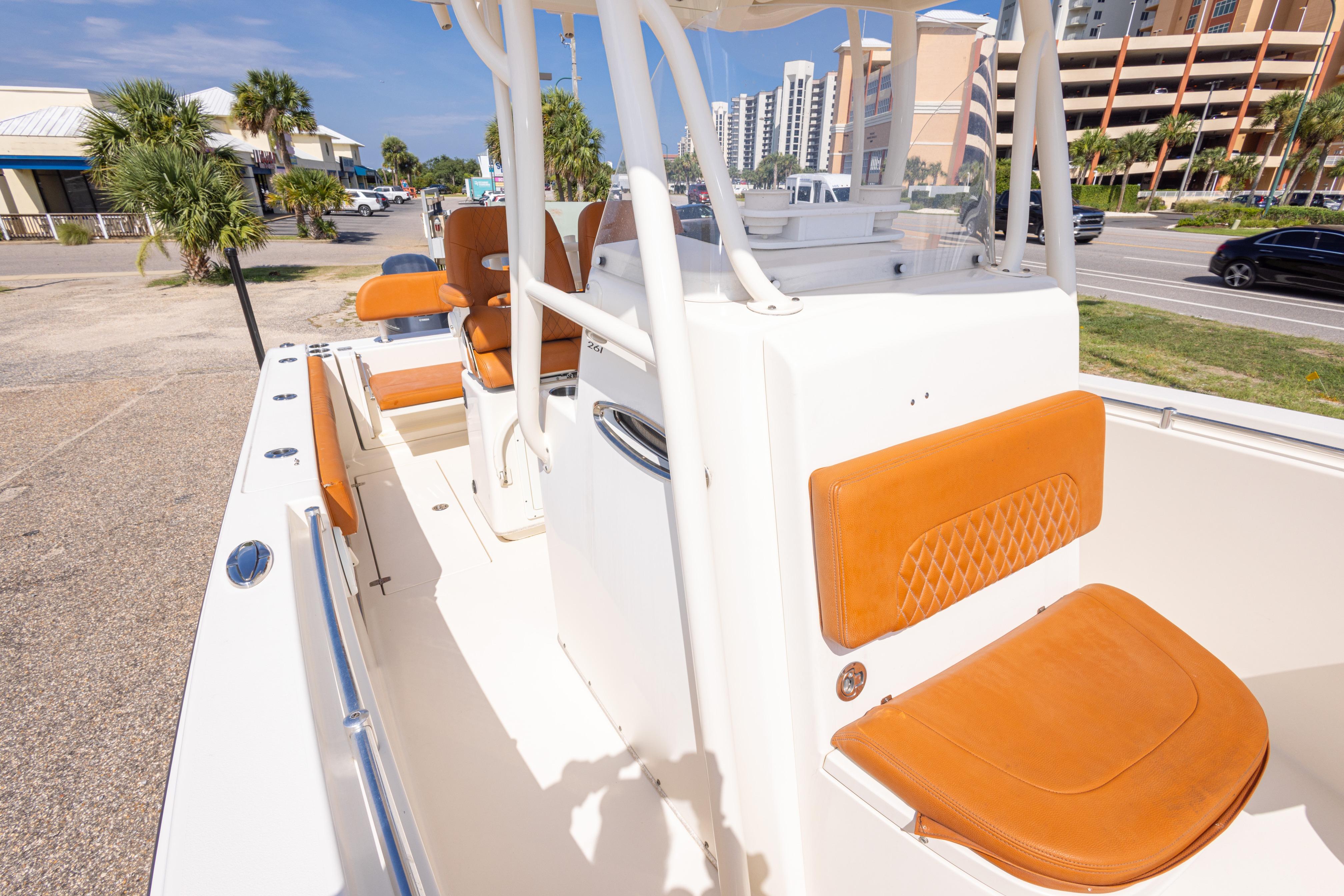 2017 Cobia 261 Center Console boat with tan seating, docked near a coastal road.