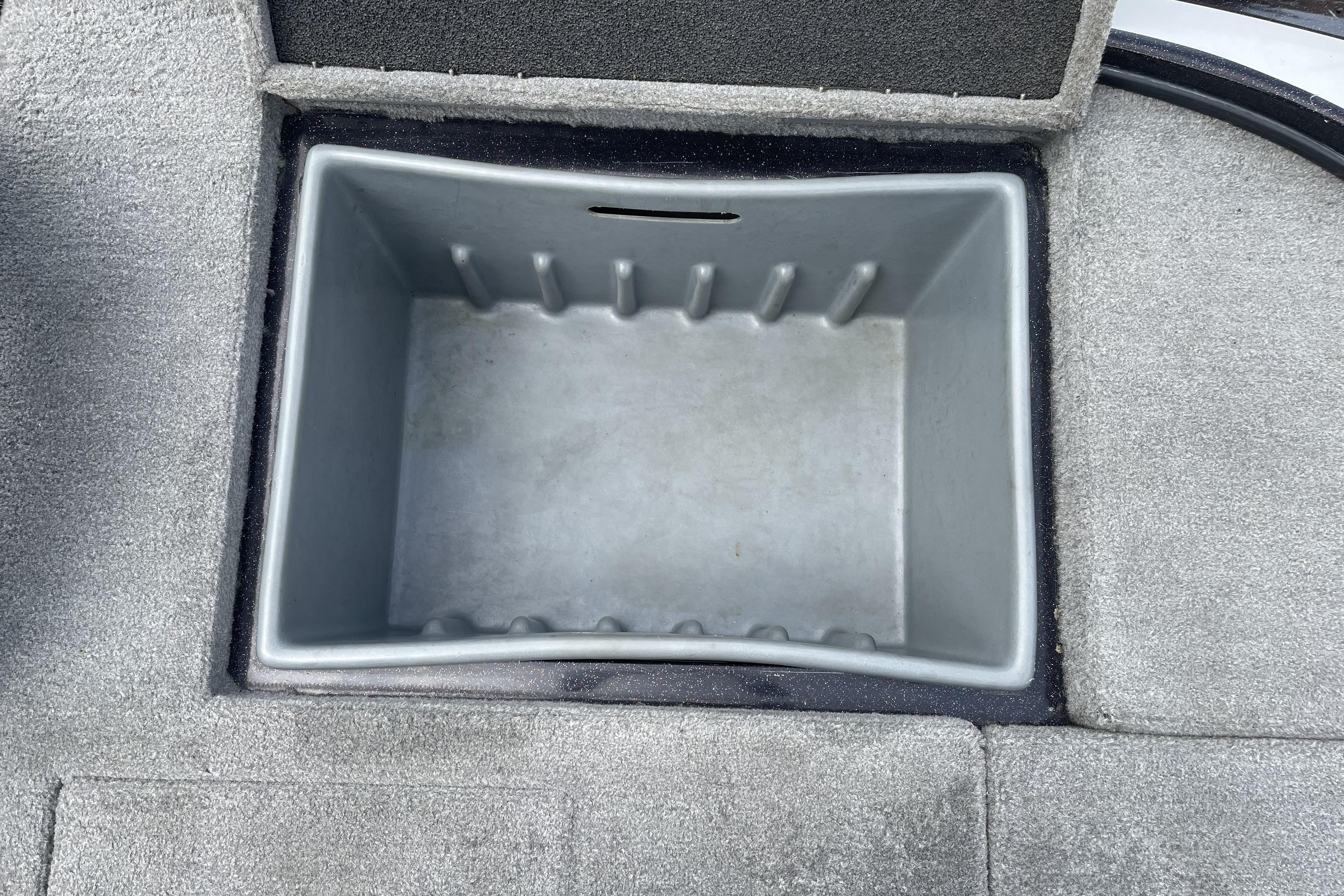 Empty storage compartment in 2013 Nitro Z-8 boat, featuring gray interior and carpeted edges.