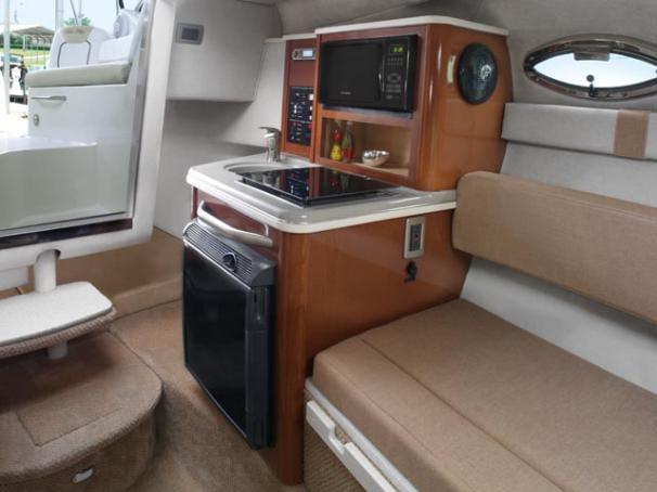 2012 Sea Ray 240 Sundancer cabin interior with kitchenette and seating area.
