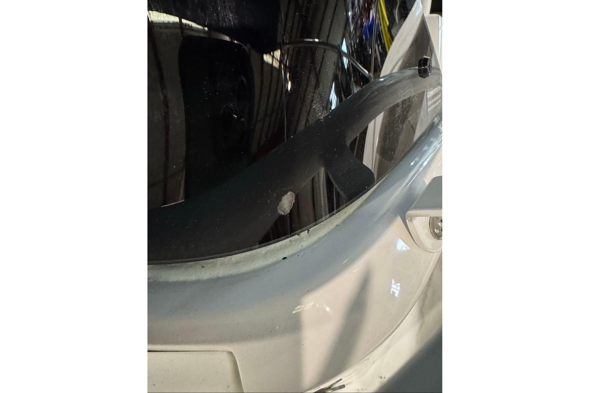 Close-up of 2026 Tahoe 2150 CC boat windshield with minor damage.