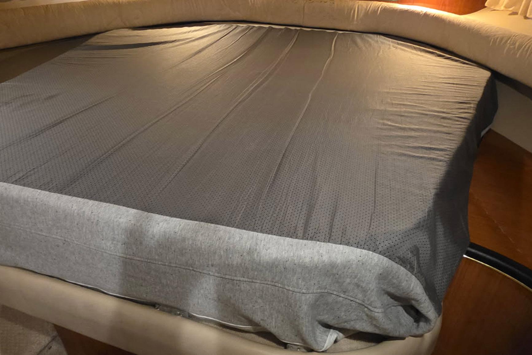 Interior cabin bed of 1998 Sea Ray Sundancer 400 yacht with gray bedding.