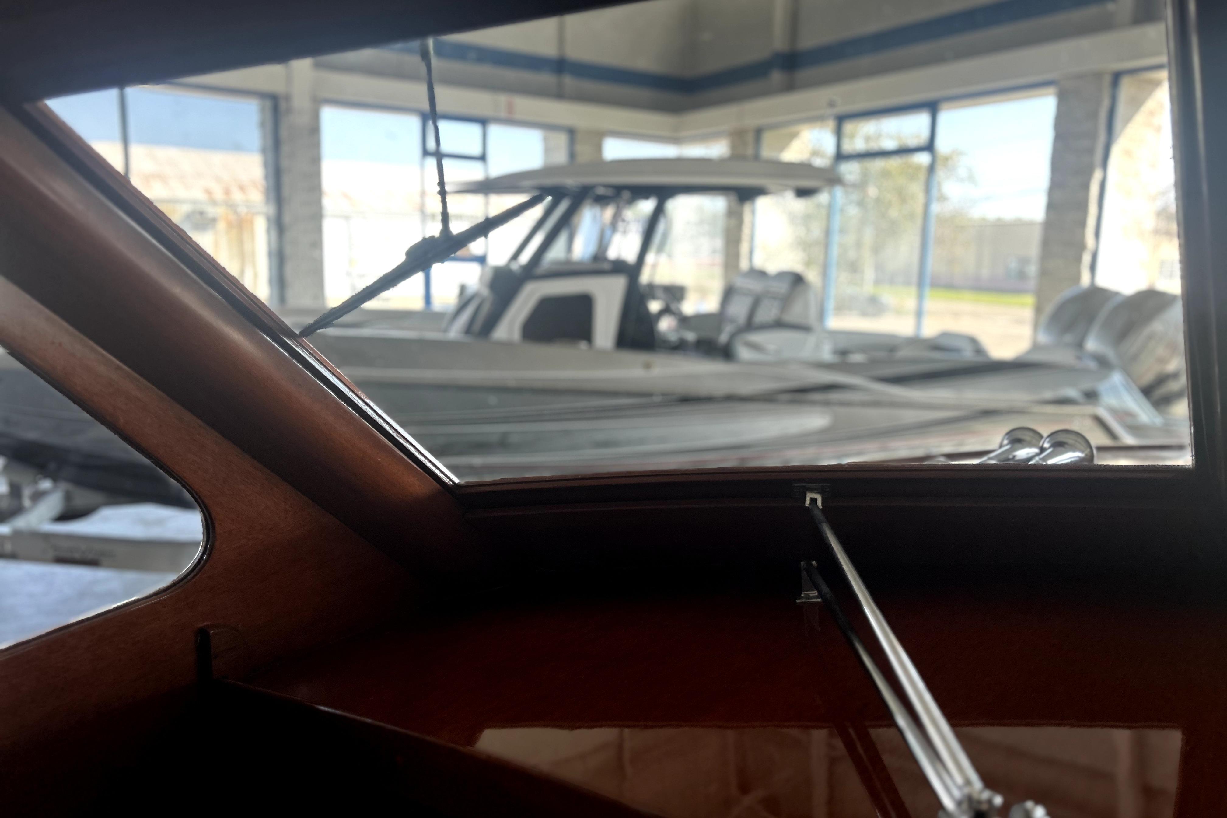 Interior view of a 1962 Prowler Forest Johnson boat, showcasing wooden details and marina background.