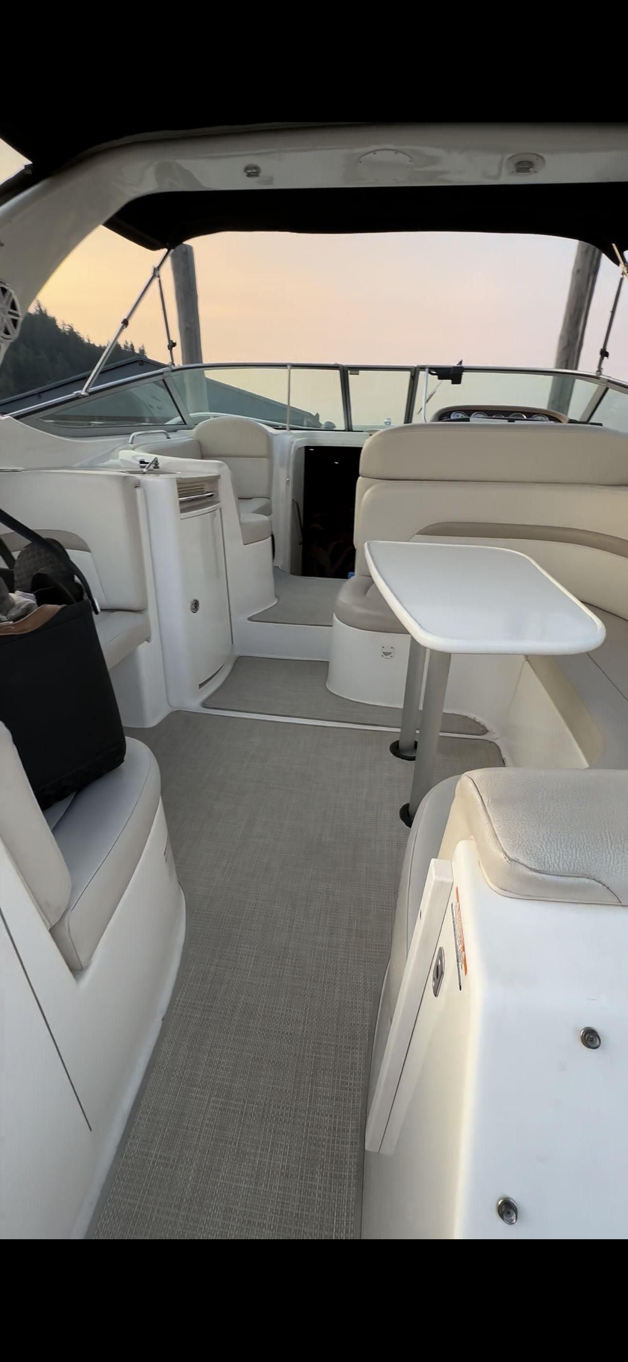 The image shows the cockpit of a 2004 Chaparral Signature 330 with beige seating and a table.