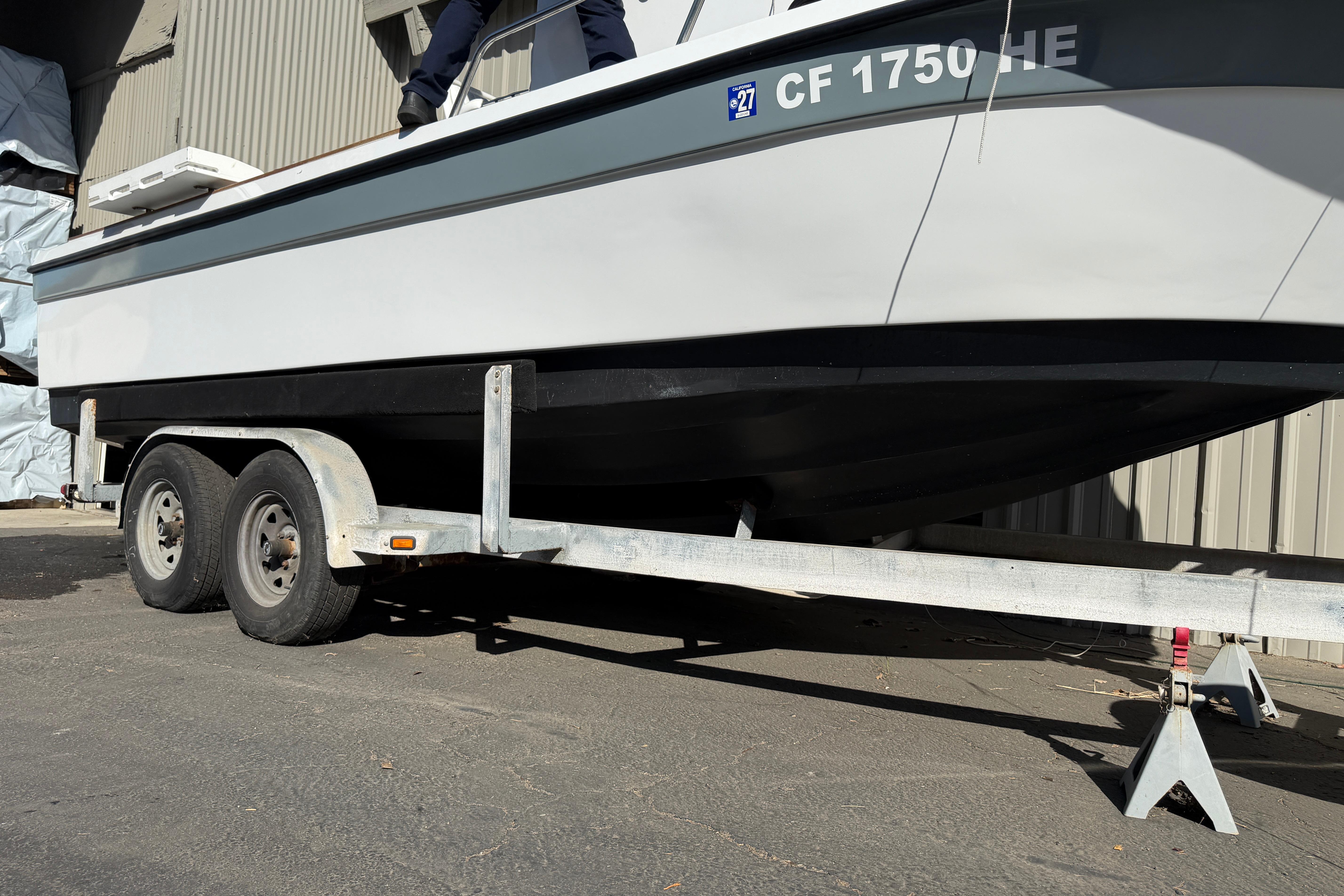 1986 Radon 21 Sport boat on trailer, parked outdoors near a building.